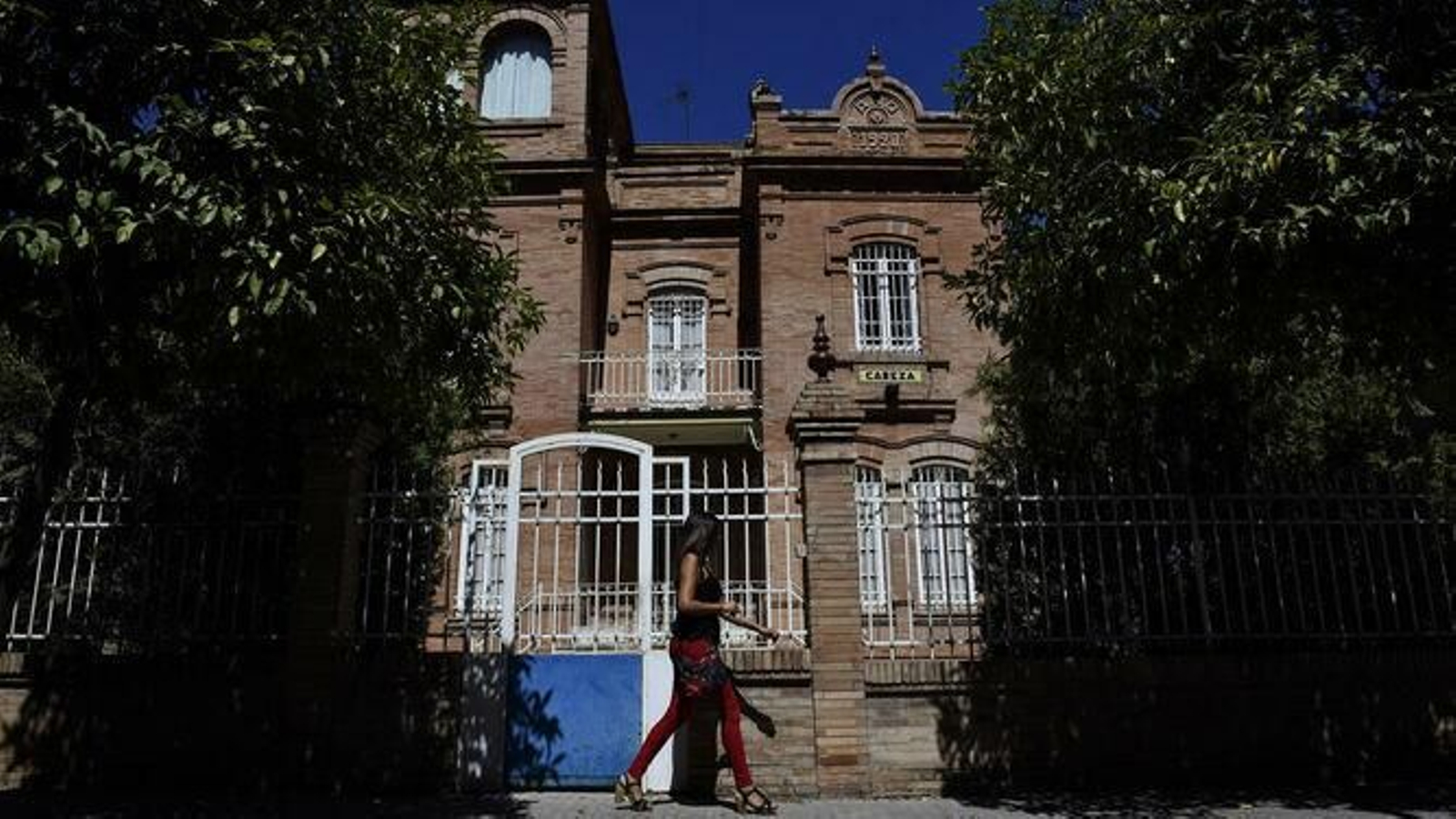 Una joven pasa ante un chalé de Aníbal González en Nervión.
