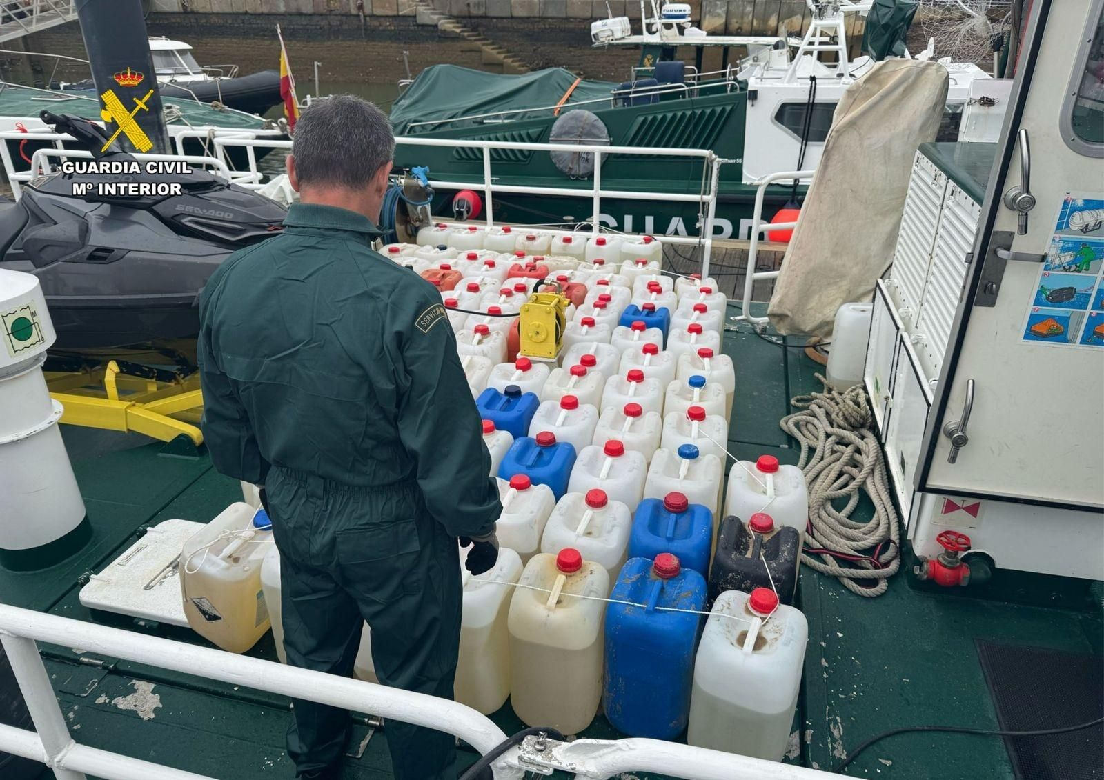 Guardia Civil con las garrafas de combustible incautadas, en una imagen de archivo.