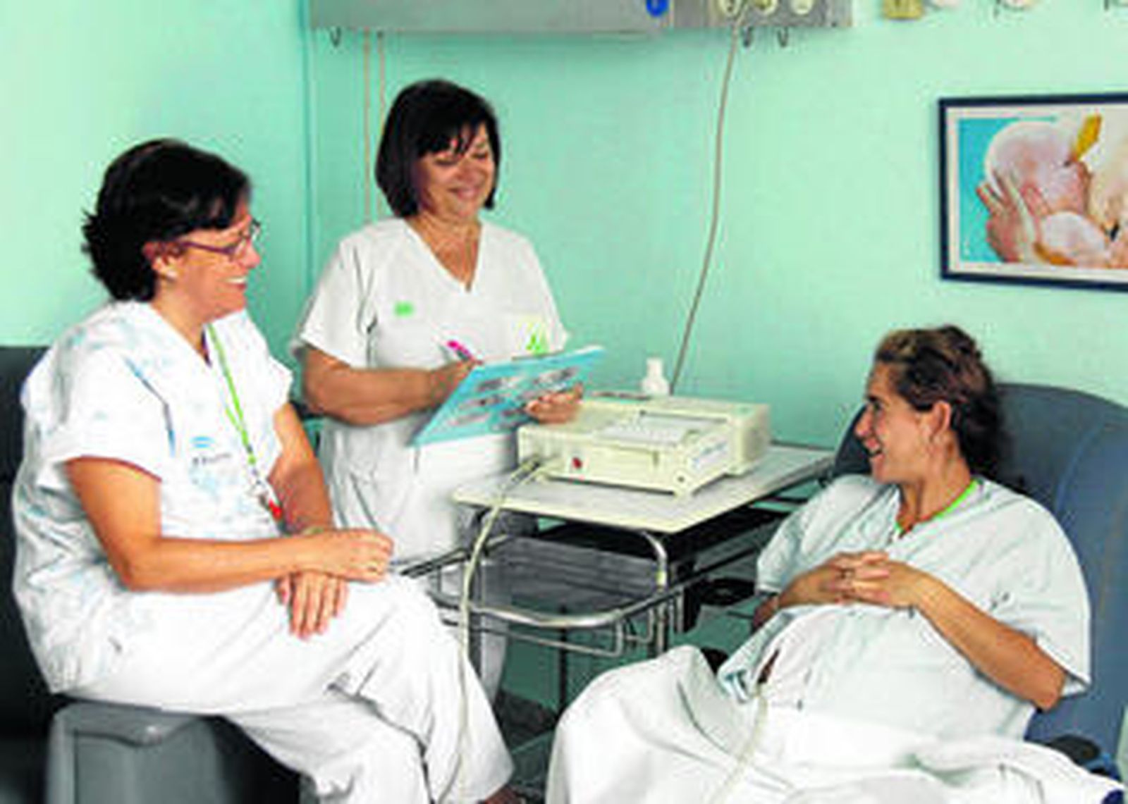 Una matrona y una auxiliar de enfermería, informando a una embarazada antes de la cesárea.