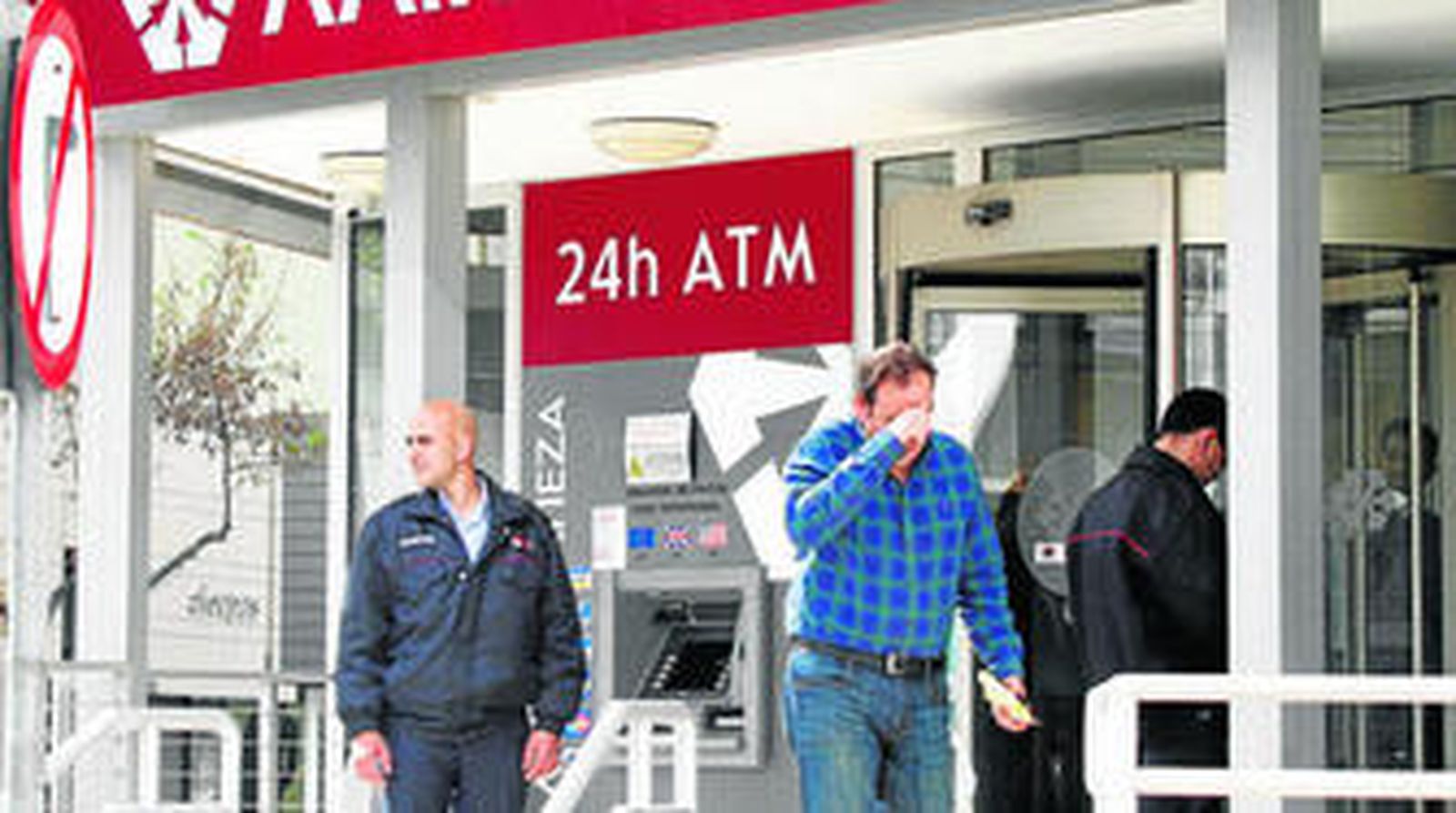 Clientes en la puerta de una sucursal del Laiki Bank en Nicosia.