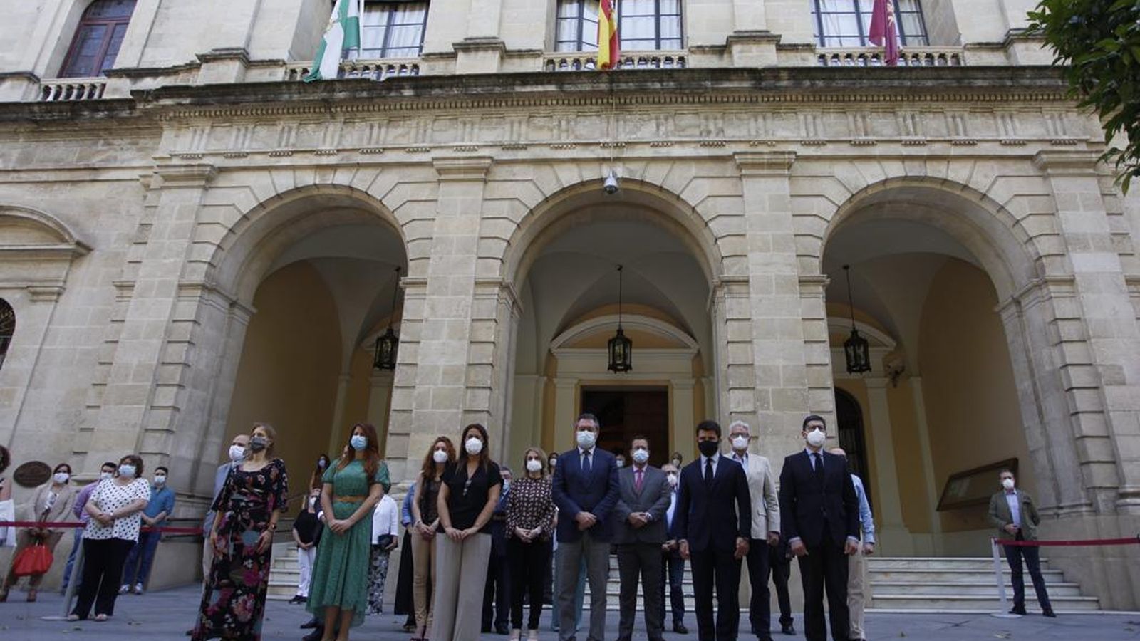 Minuto de silencio por las víctimas del coronavirus ante el Ayuntamiento de Sevilla.