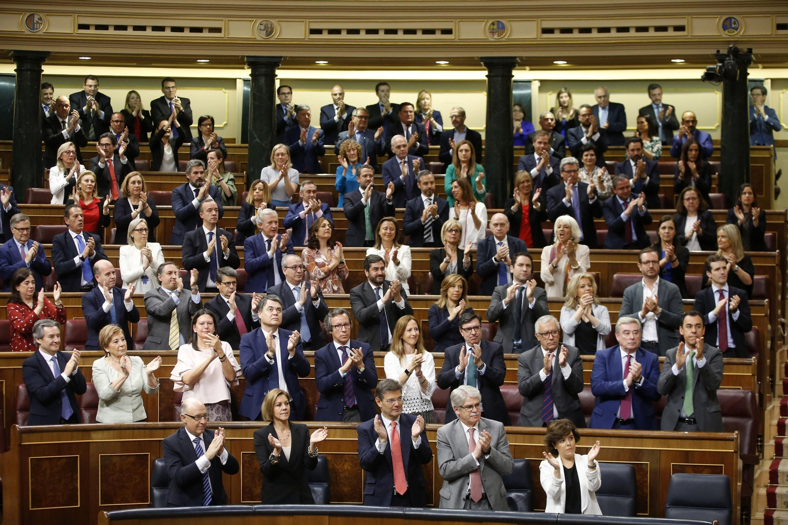 La bancada del PP en pie aplaudiendo a su portavoz.