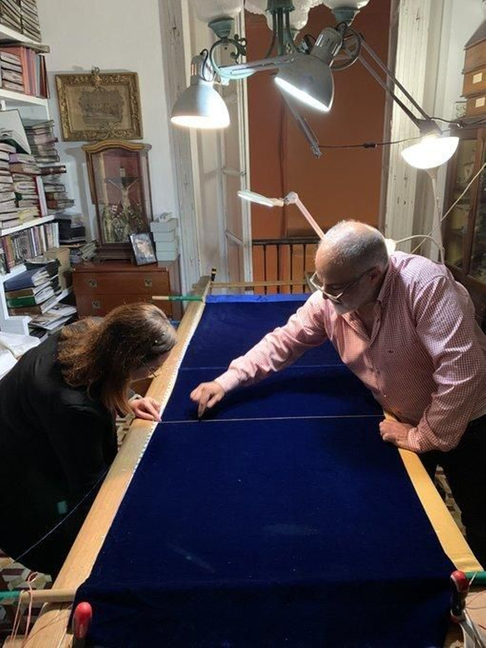 La hermana mayor de Expiración, Elisa Montero, da la primera puntada de la nueva bambalina delantera del palio, que va a bordar Juan Carlos Romero.