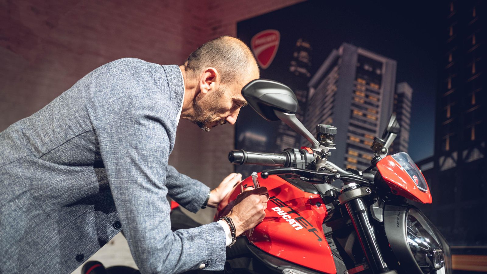 Claudio Domenicali, CEO de Ducati, firmando el depósito de una de las motos expuestas durante el evento de presentación del acuerdo. Claudio Domenicali, CEO de Ducati, firmando el depósito de una de las motos expuestas durante el evento de presentación del acuerdo.