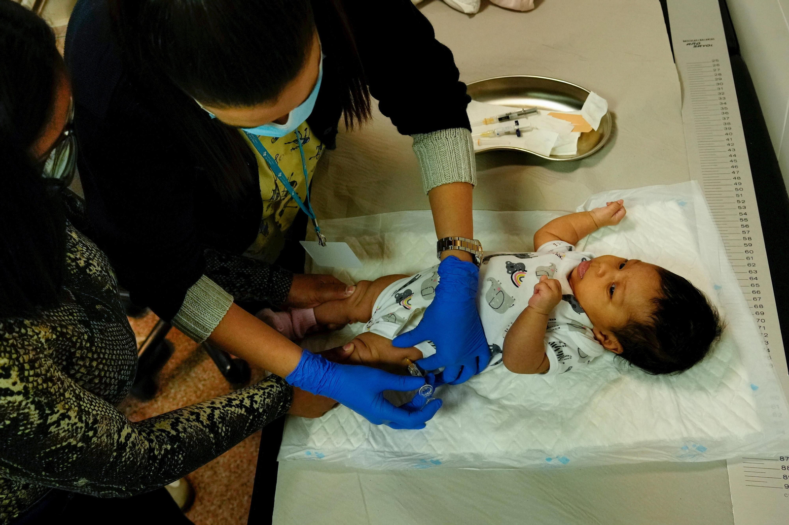 Una enfermera inocula una vacuna a un bebé en el centro de salud