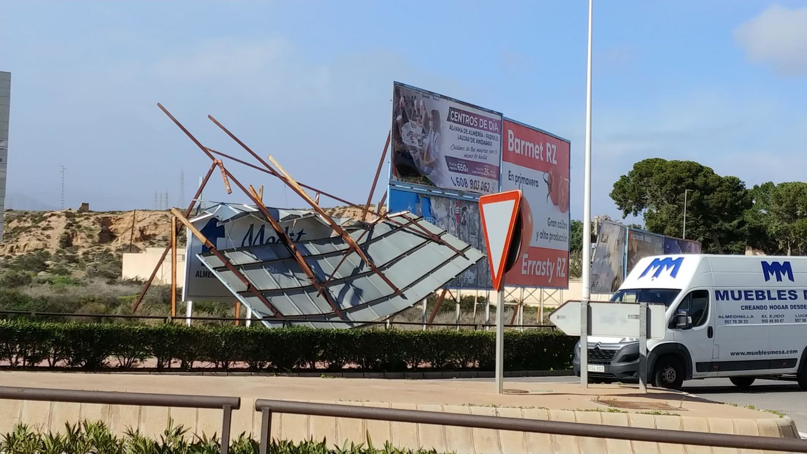 El viento derriba una valla publicitaria en la carretera N-340 en Benahadux