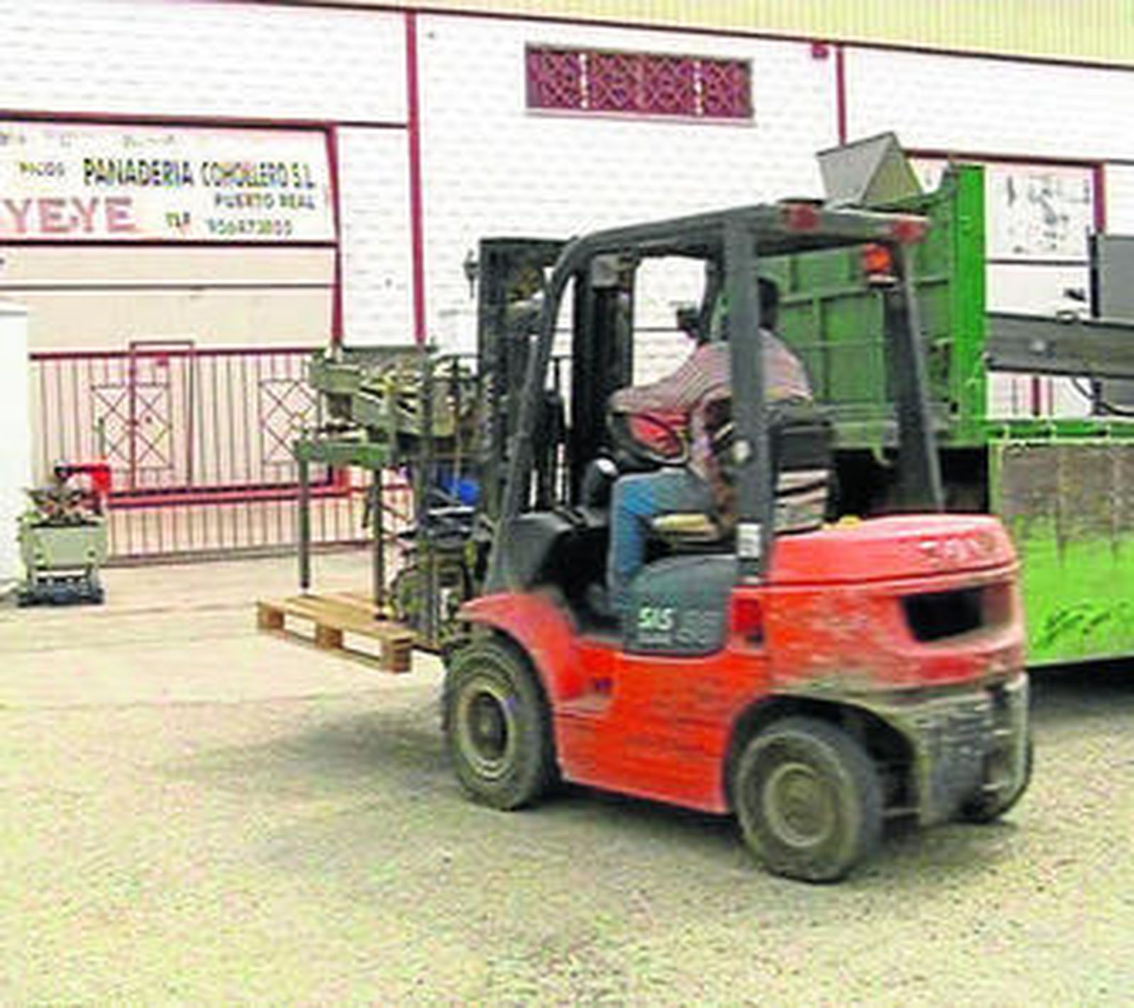 Un empleado traslada maquinaria hasta el interior de la empresa