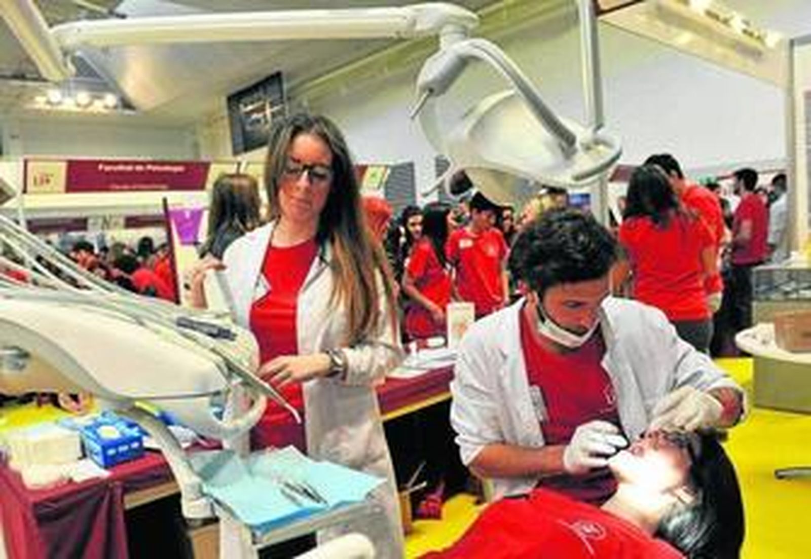 Un estudiante de Odontología revisa la higiene bucal de una joven.
