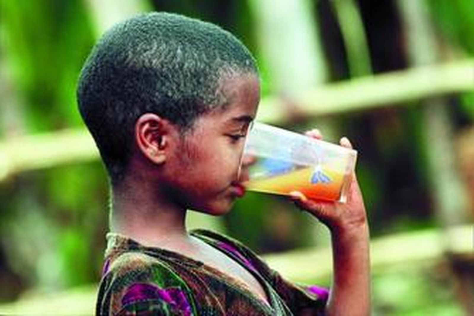Un niño bebe un vaso de zumo en Etiopía.