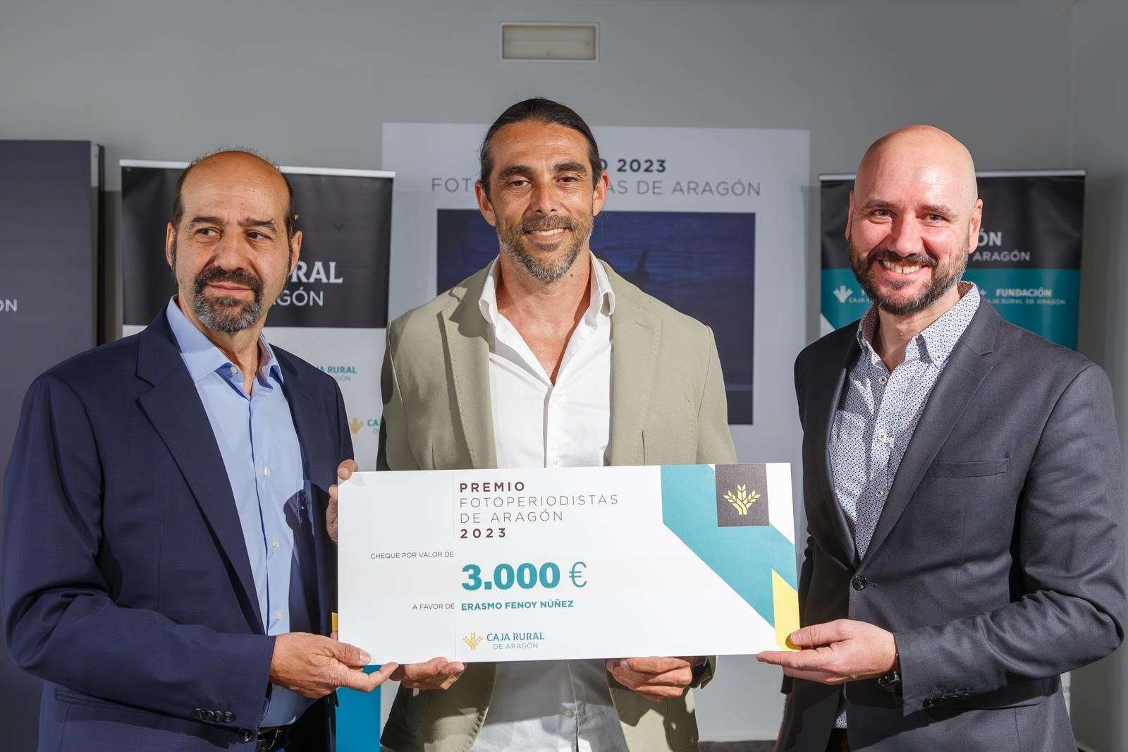 Erasmo Fenoy con el premio junto a Íñigo Martínez, flanqueado por el director de comunicación de Caja Rural y el presidente de la Asociación de fotoperiodistas de Aragón, Javier Cebollada.