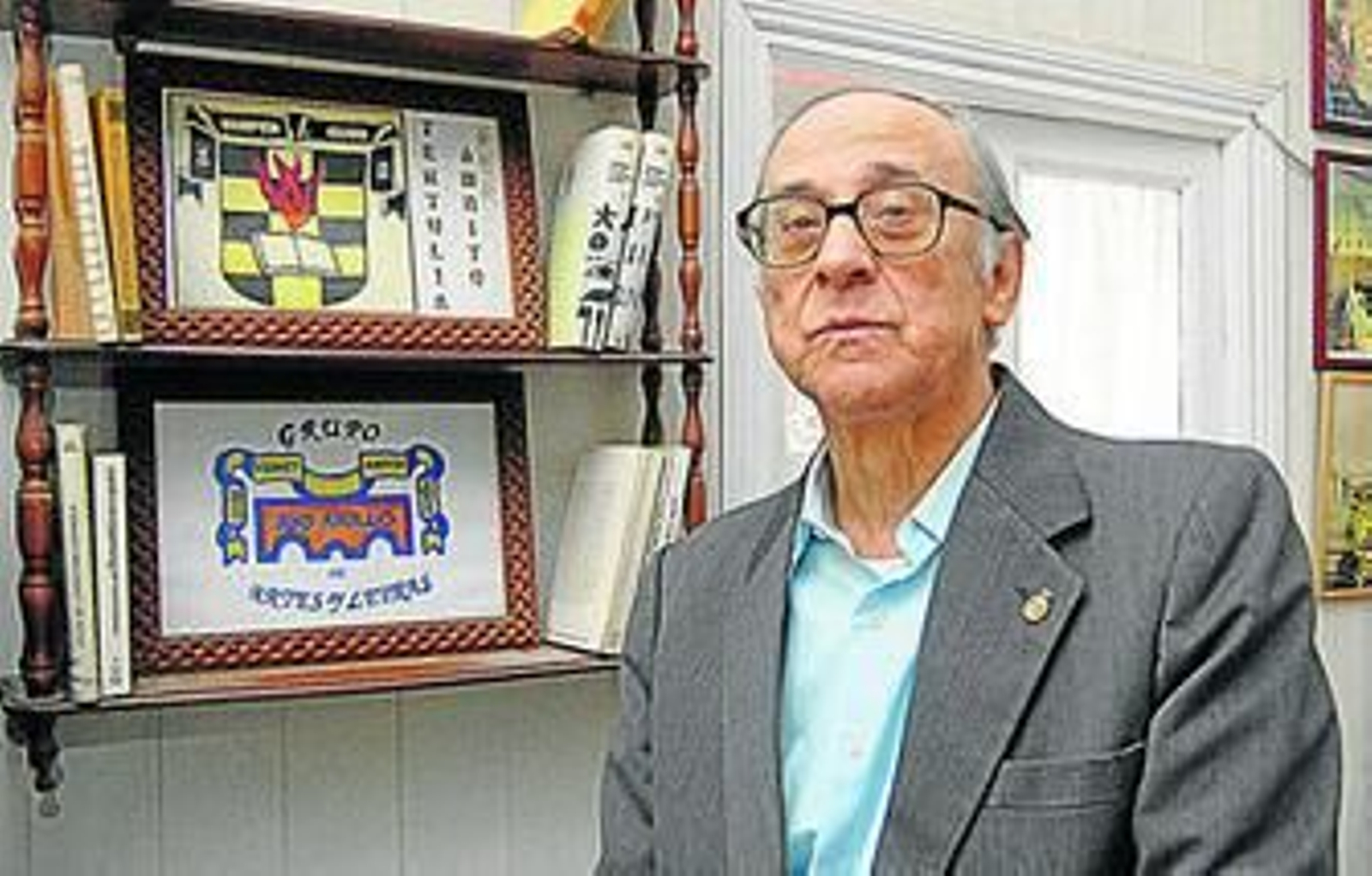 Juan Rafael Mena, ayer en su casa, posa delante de libros y recuerdos.