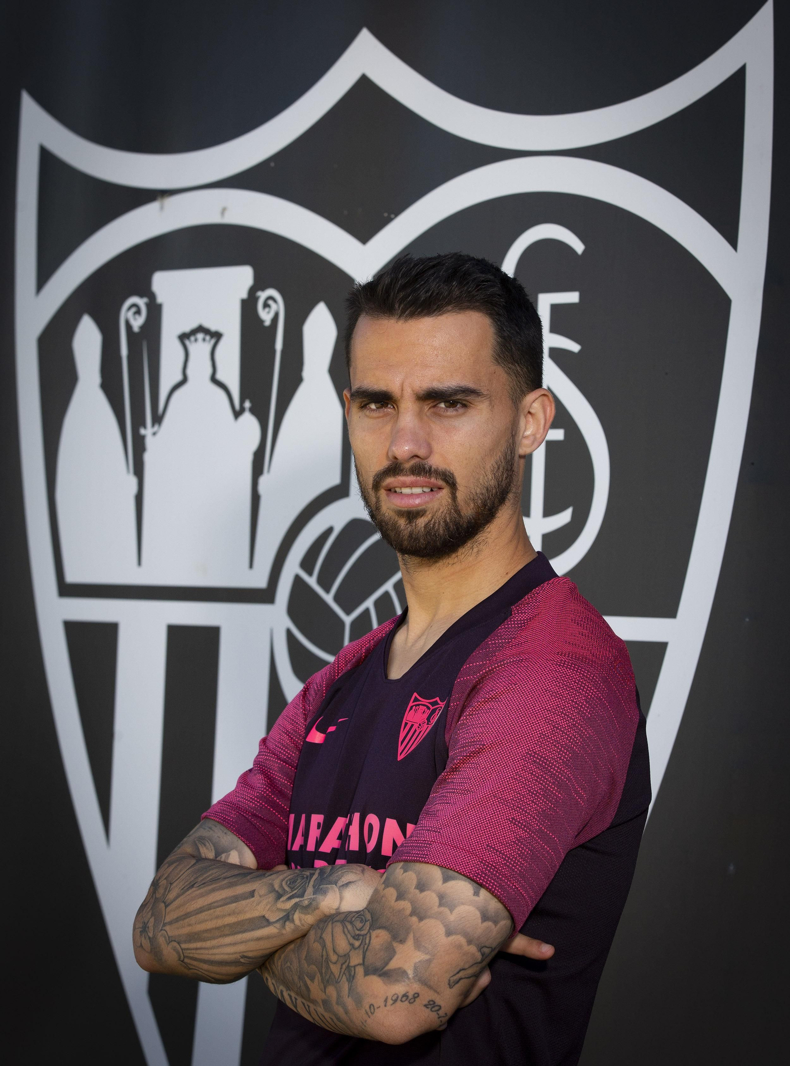 Suso, ante el escudo del Sevilla.