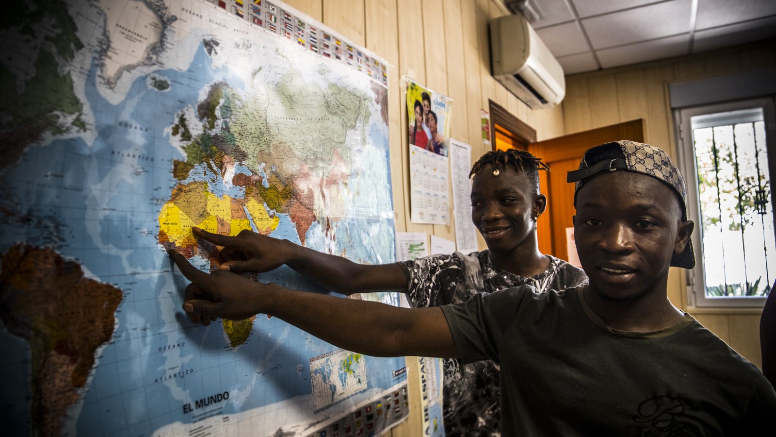 Souleyman Condé (derecha) y Fousseiny Tounkara (izquierda señalan en un mapa mundi donde se encuentran sus países