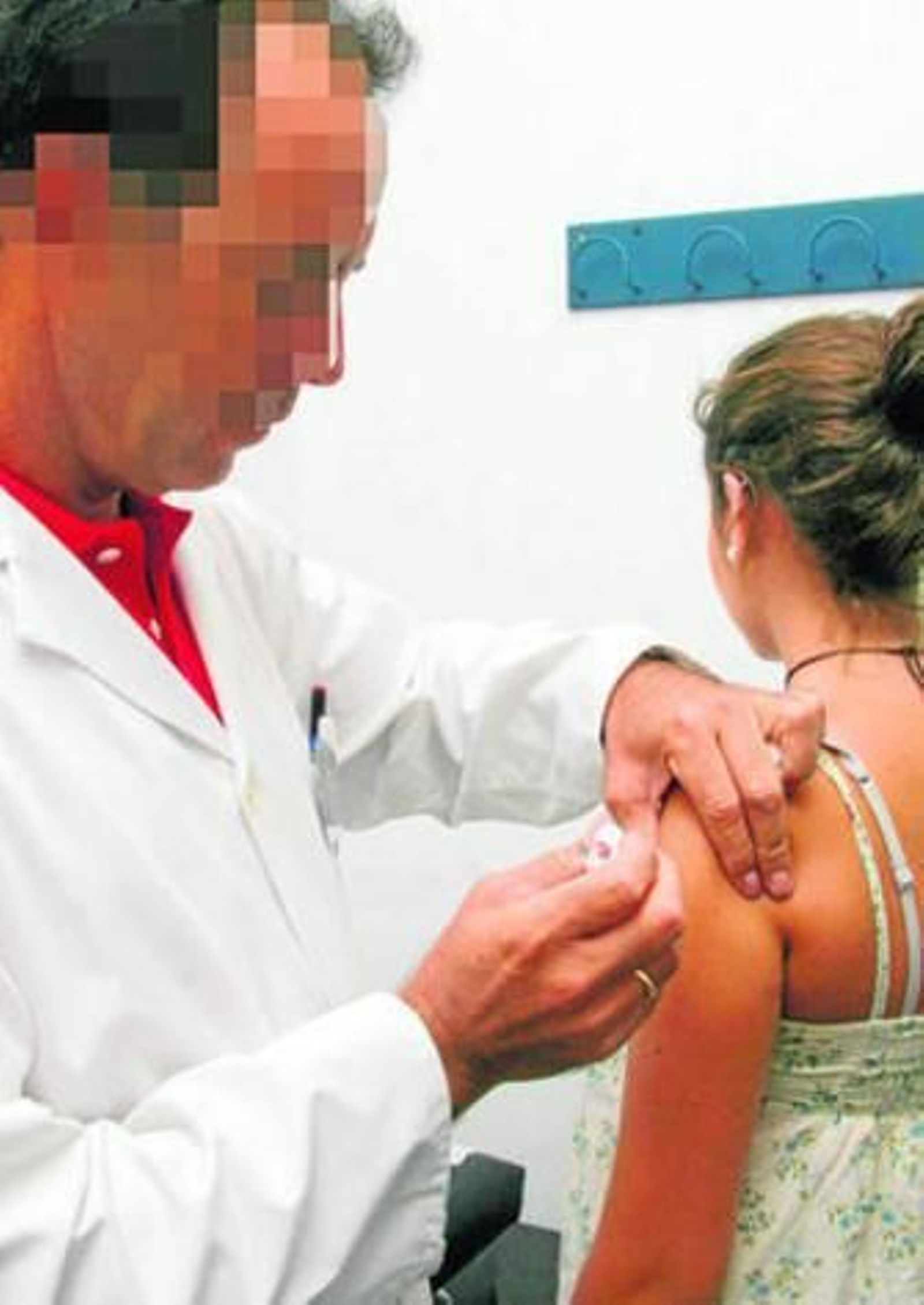 Un enfermero vacuna a una niña.