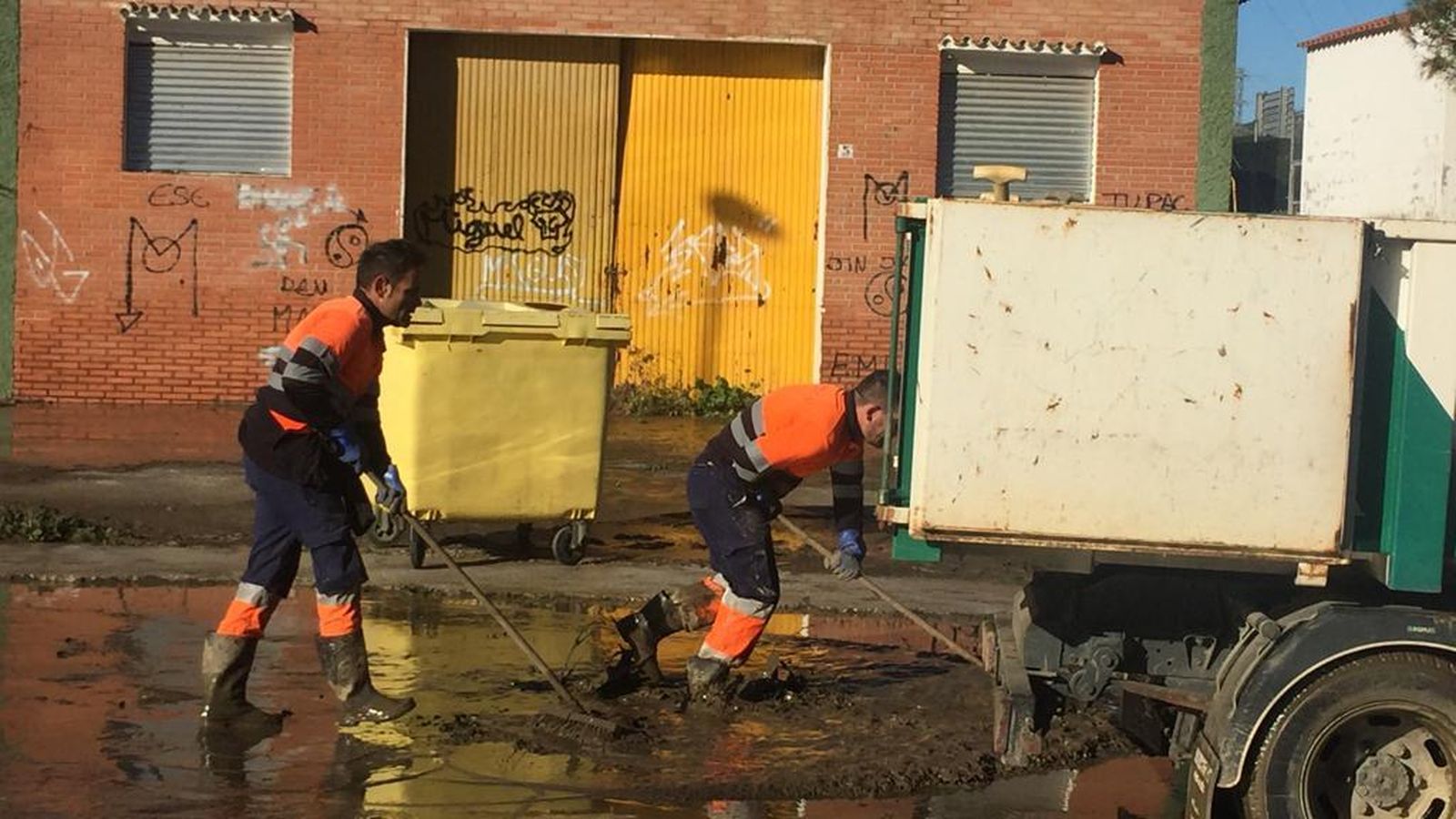 Operarios limpian el barro de las calles de El Trapiche, en Vélez-Málaga.