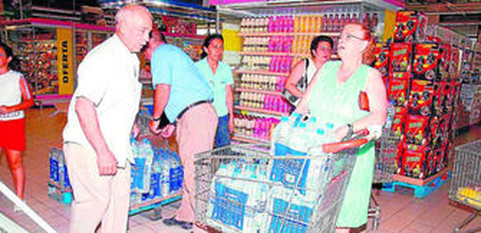 Estas personas se aprovisionan de agua embotellada en un centro comercial.