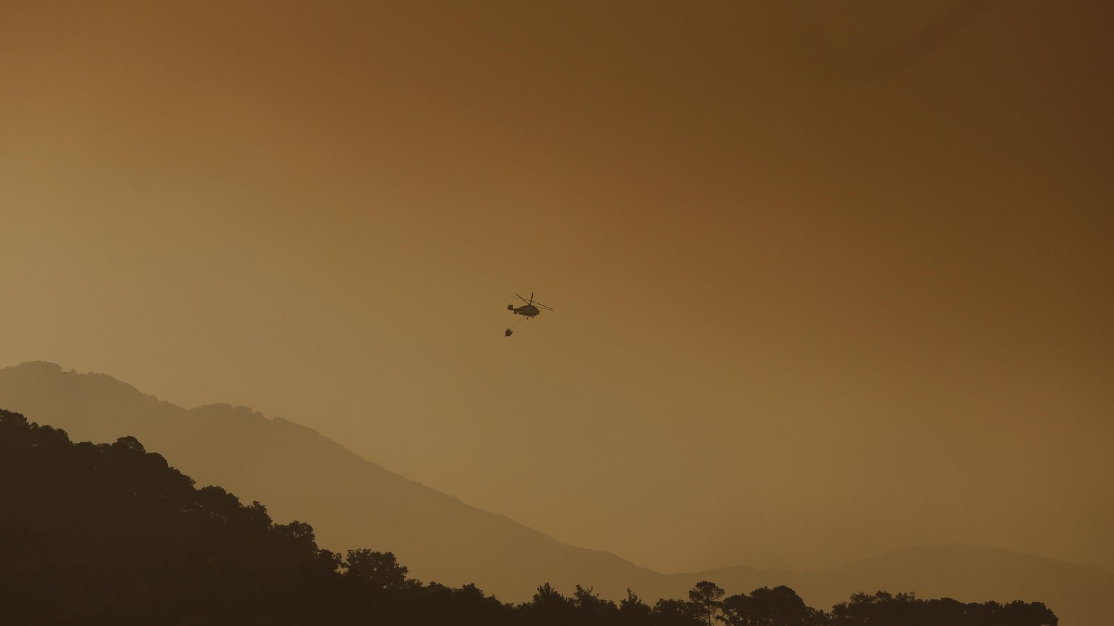 Helicópteros trabajando sobre el incendio al amanecer Helicópteros trabajando sobre el incendio al amanecer