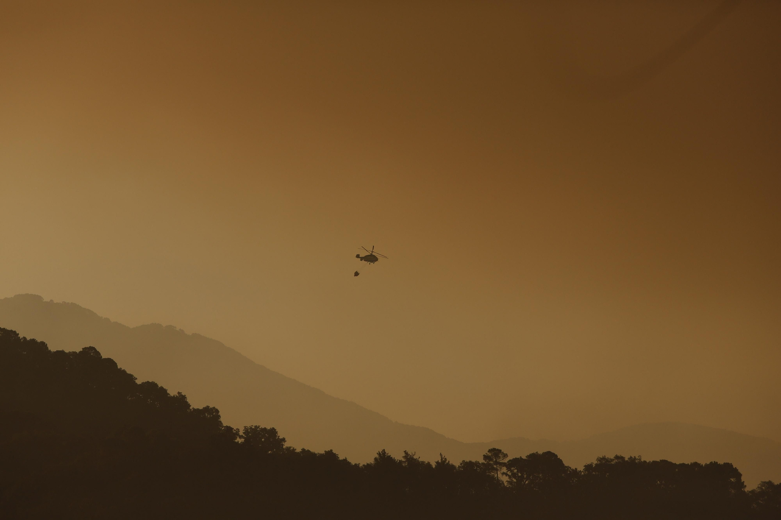 Helicópteros trabajando sobre el incendio al amanecer