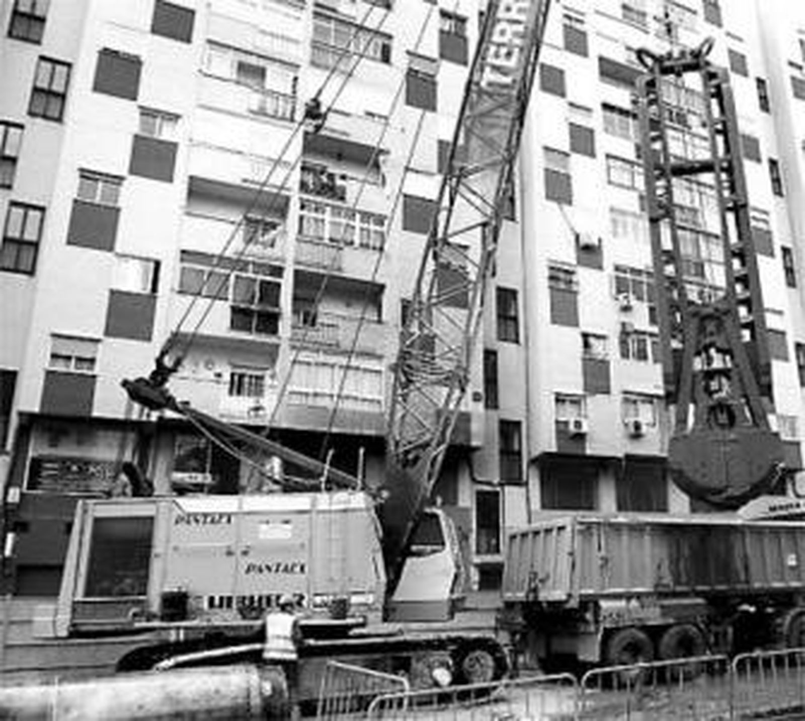 Una pantalladora trabaja junto a la fachada de un edificio.