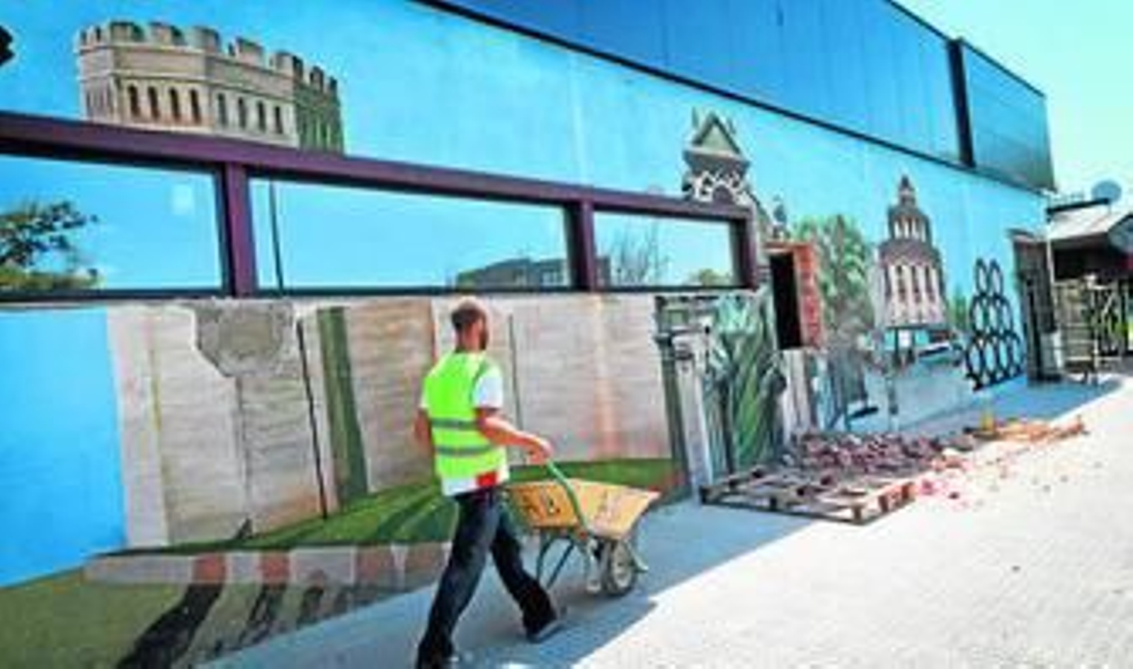 Imagen de lo que queda del grafiti, mientras un trabajador recoge escombros.