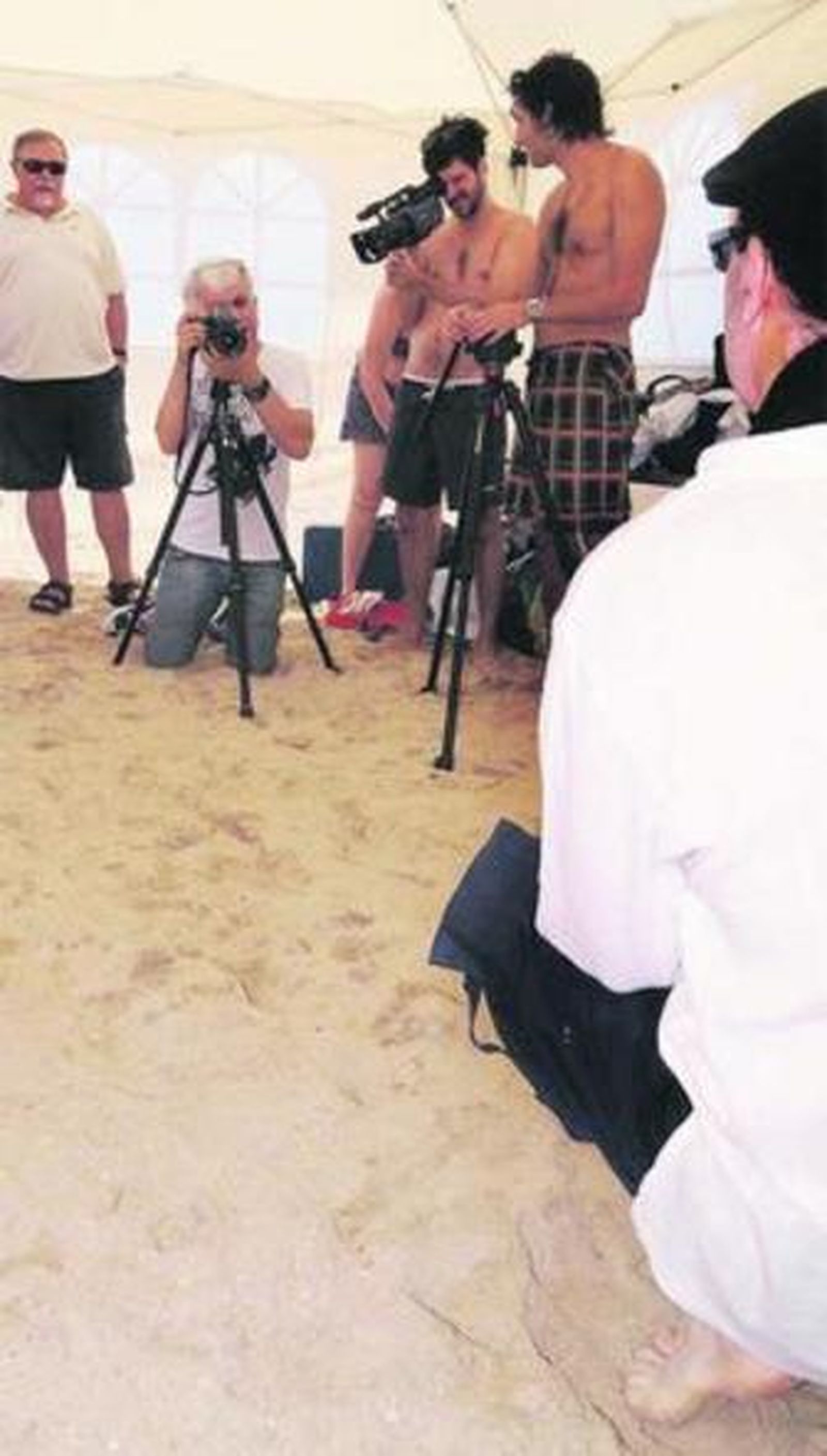 Julián Ochoa al fondo con su cámara toma una foto a un ciudadano.