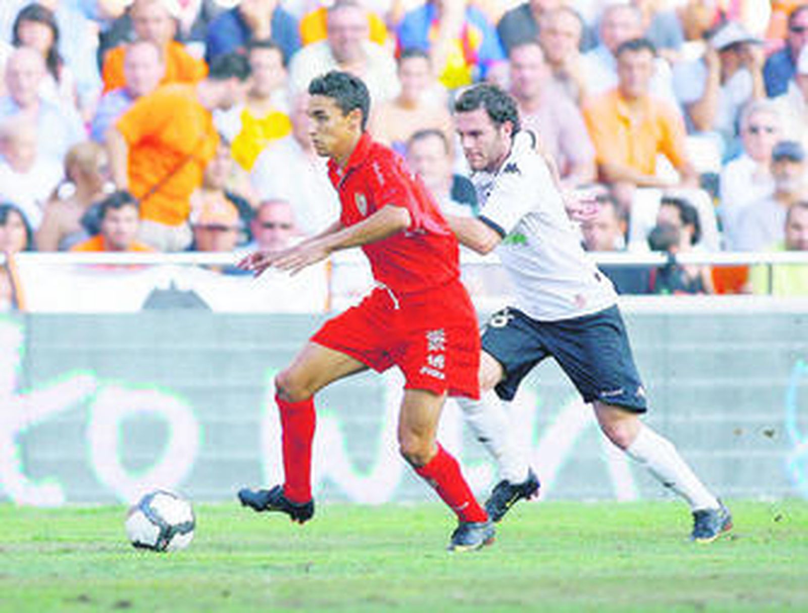 Jesús Navas trata de conducir el balón delante de Mata a pesar de las dificultades que ofrecía el terreno de juego.