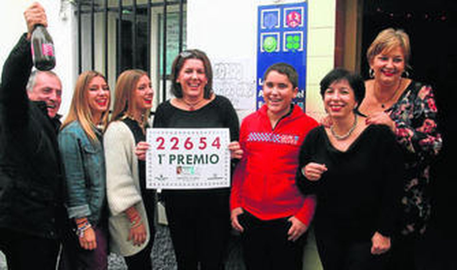 Pepi Trujillo muestra un cartel con el número del primer premio, rodeada de su familia.