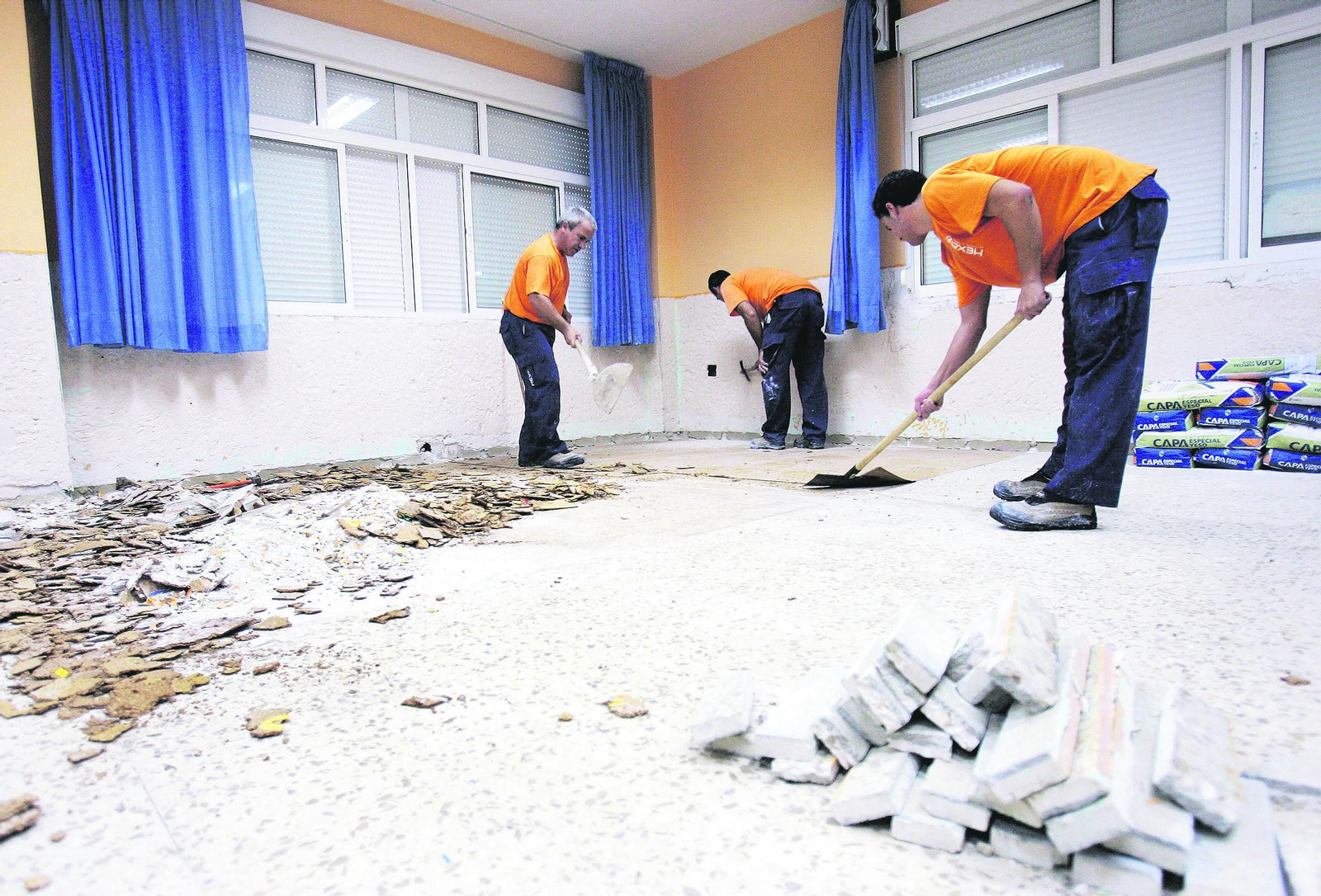 Operarios arreglan el suelo de una clase