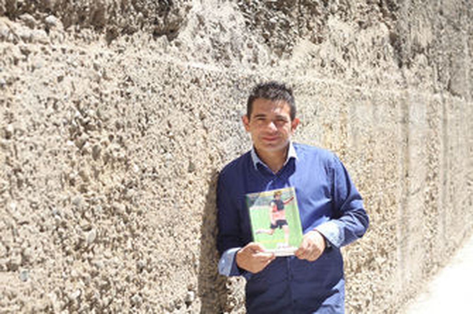 Gabriel Reyes posa con uno de sus libros sobre la muralla de la Macarena.