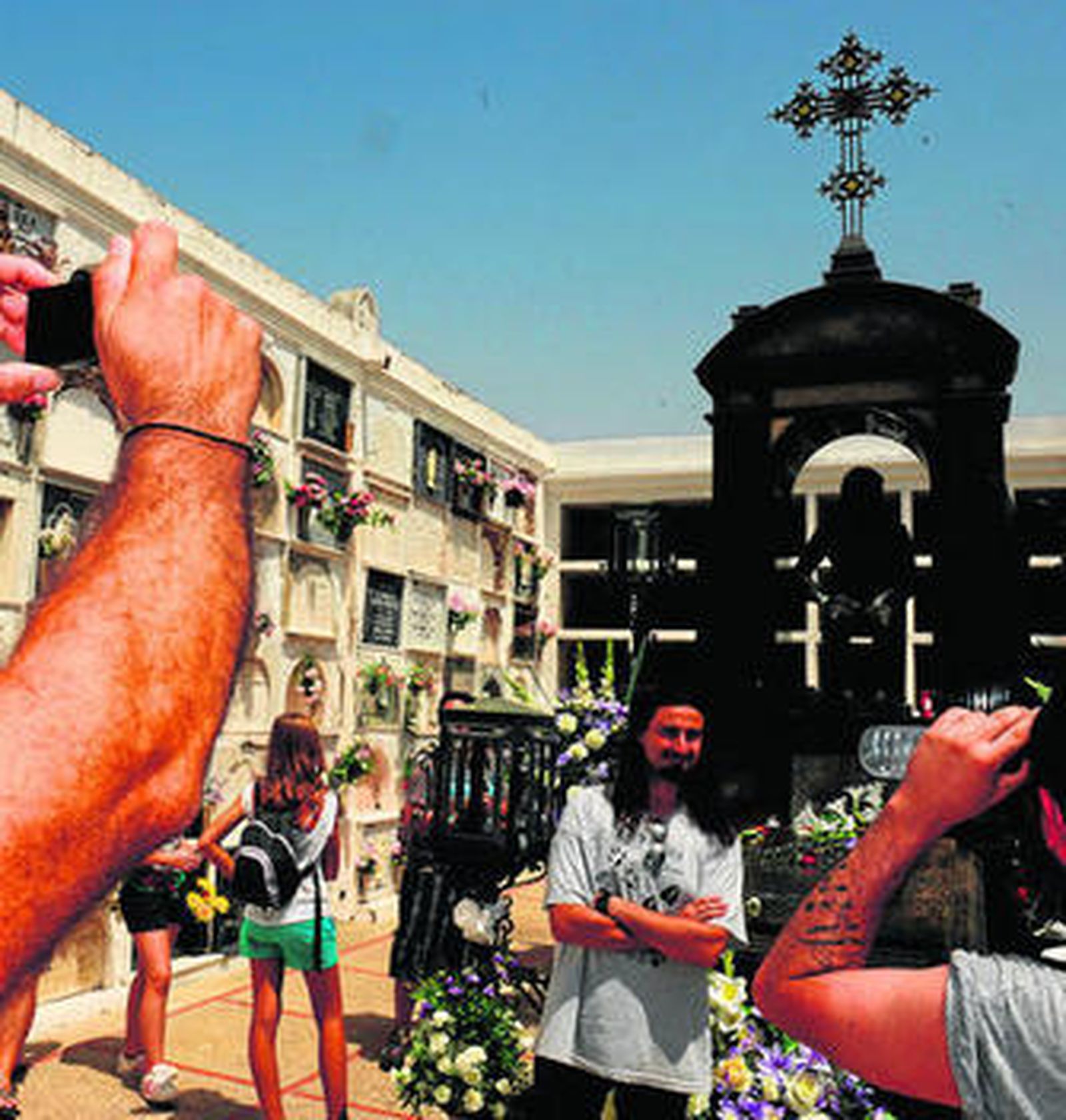 Seguidores del cantaor fotografiándose frente a su mausoleo en el cementerio.