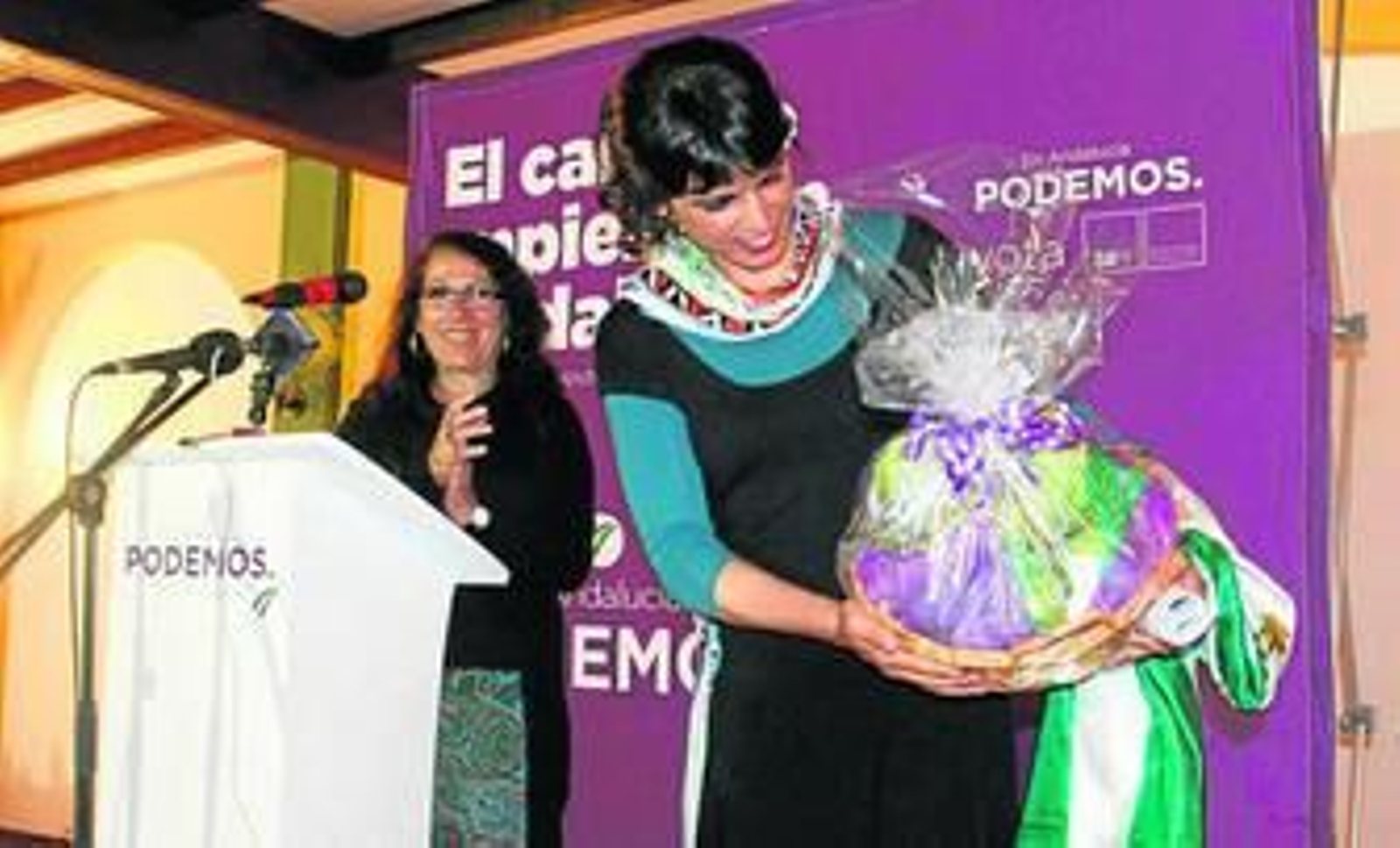 Teresa Rodríguez recibe ayer en El Coronil una cesta de alcachofas.