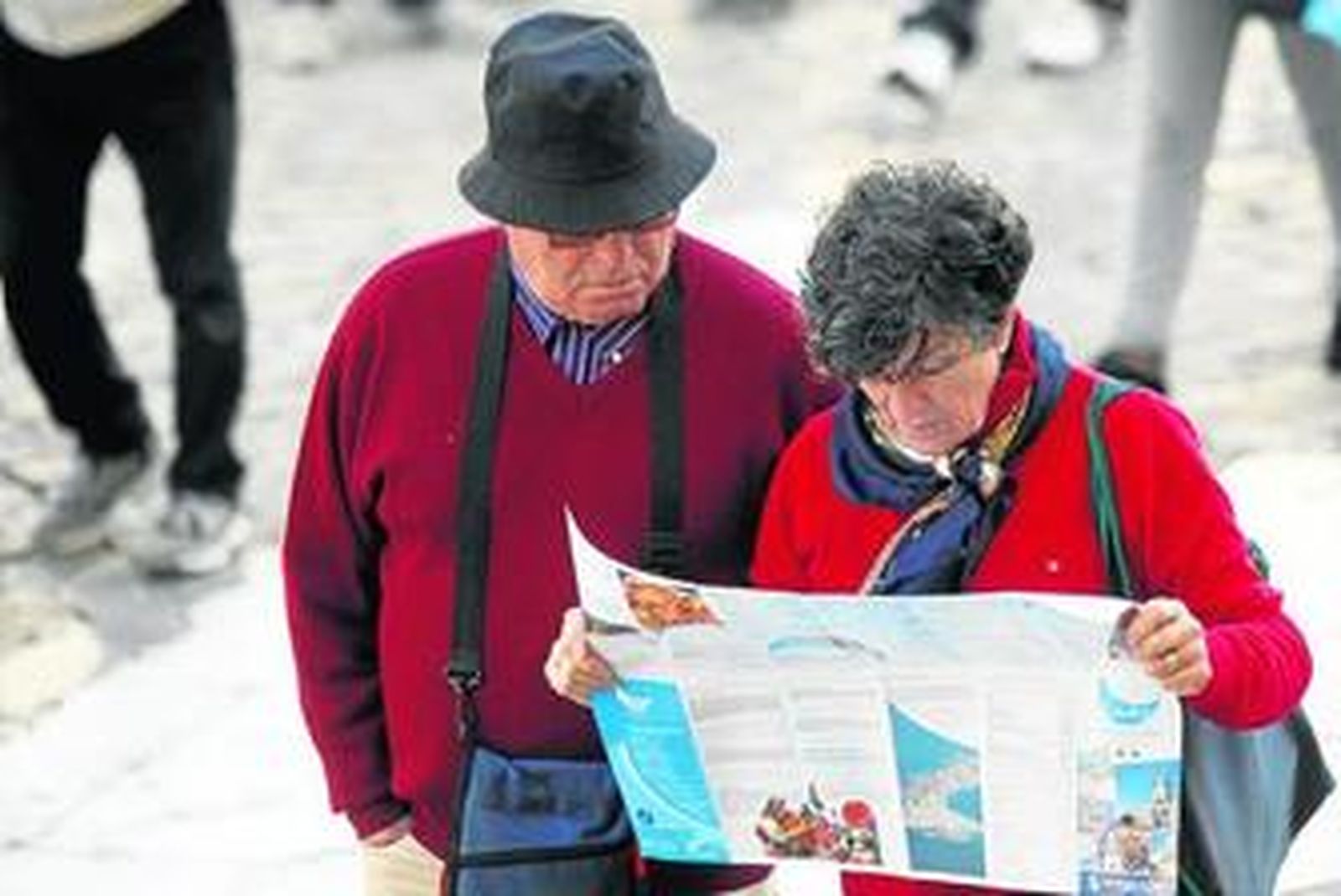 Dos turistas ojean un plano de los que distribuye el Ayuntamiento de Cádiz, mientras pasean por la ciudad.