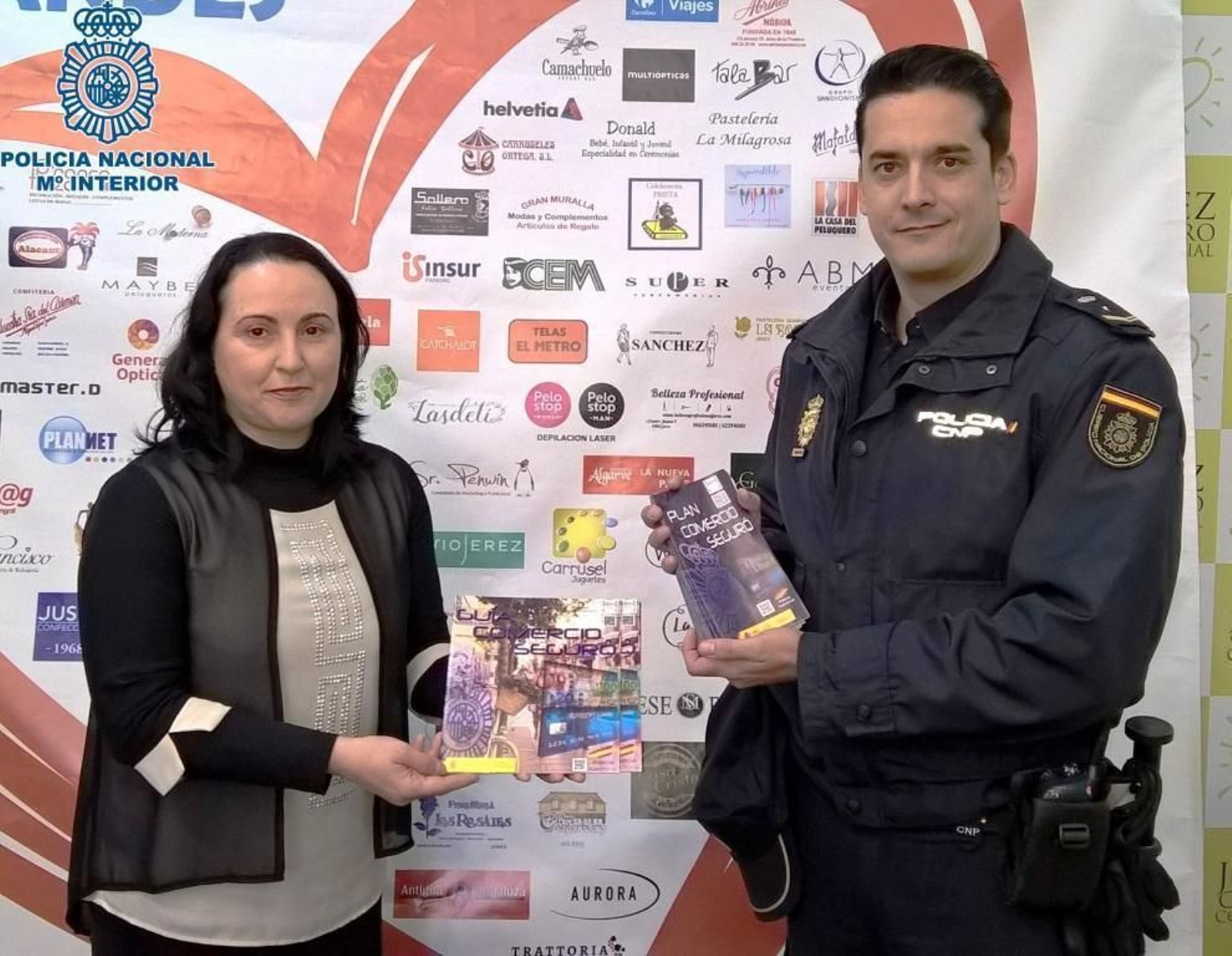 Nela García (Acoje) recibe el tríptico con las recomendaciones policiales.