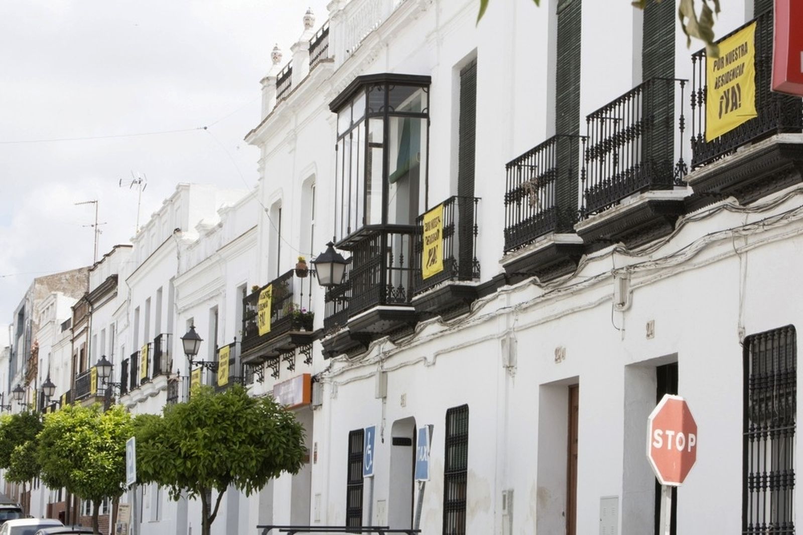 Balcones de Cazalla de la Sierra con pancartas reclamando la residencia.