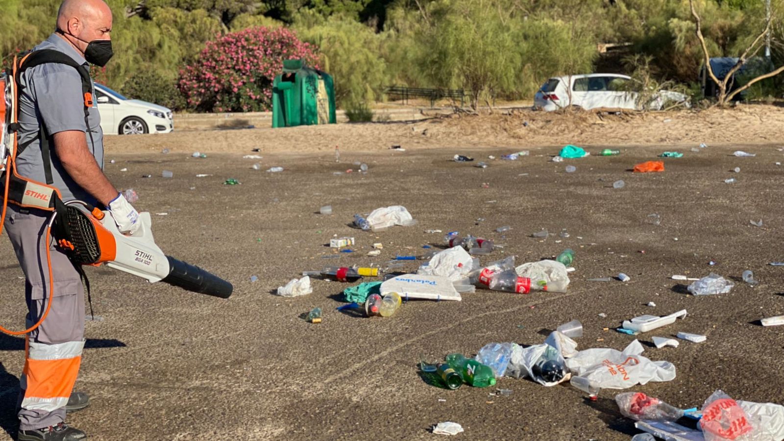 Un operario de playas, limpiando los restos de uno de los botellones.