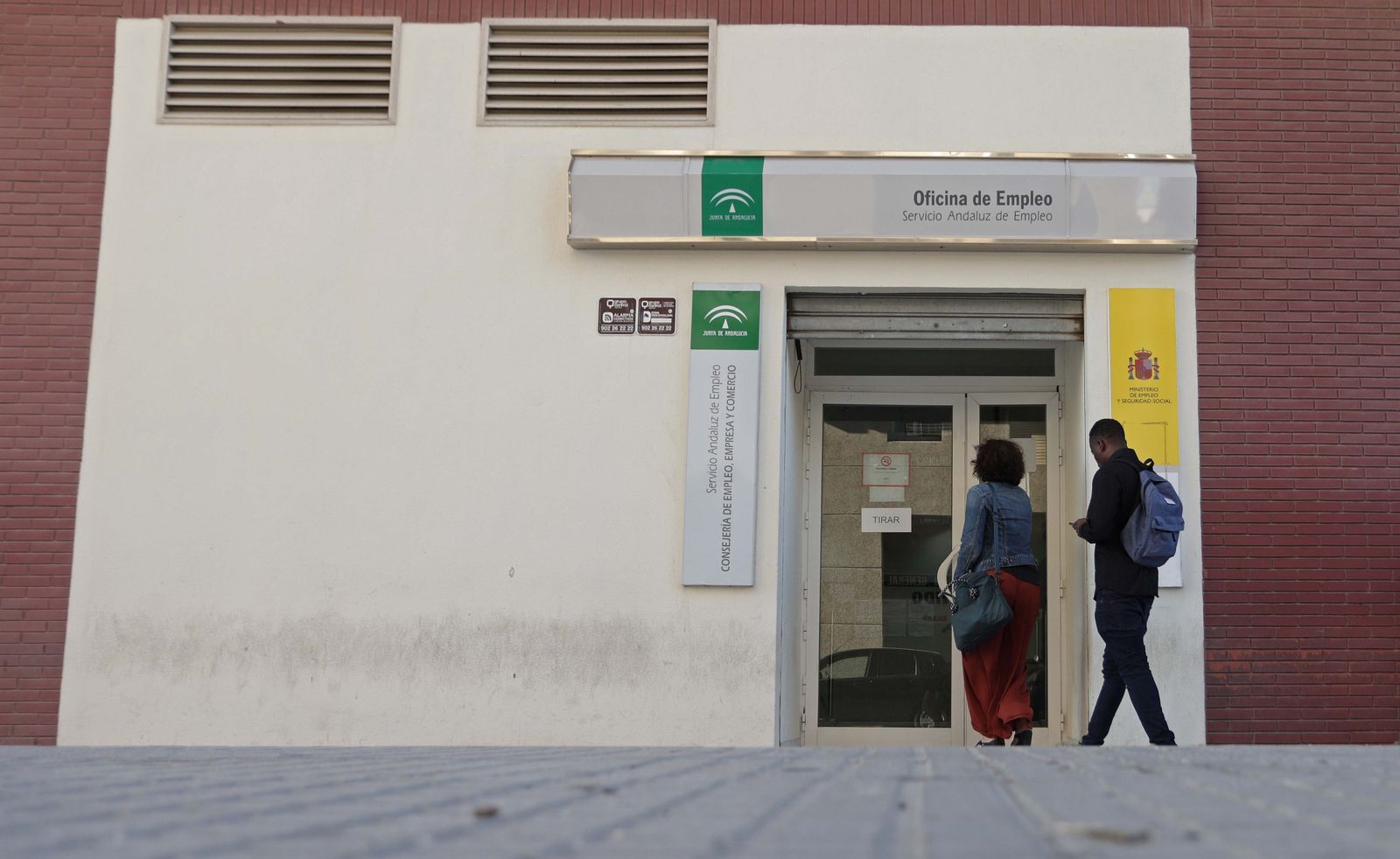 Varias personas acceden a una oficina del SAE.