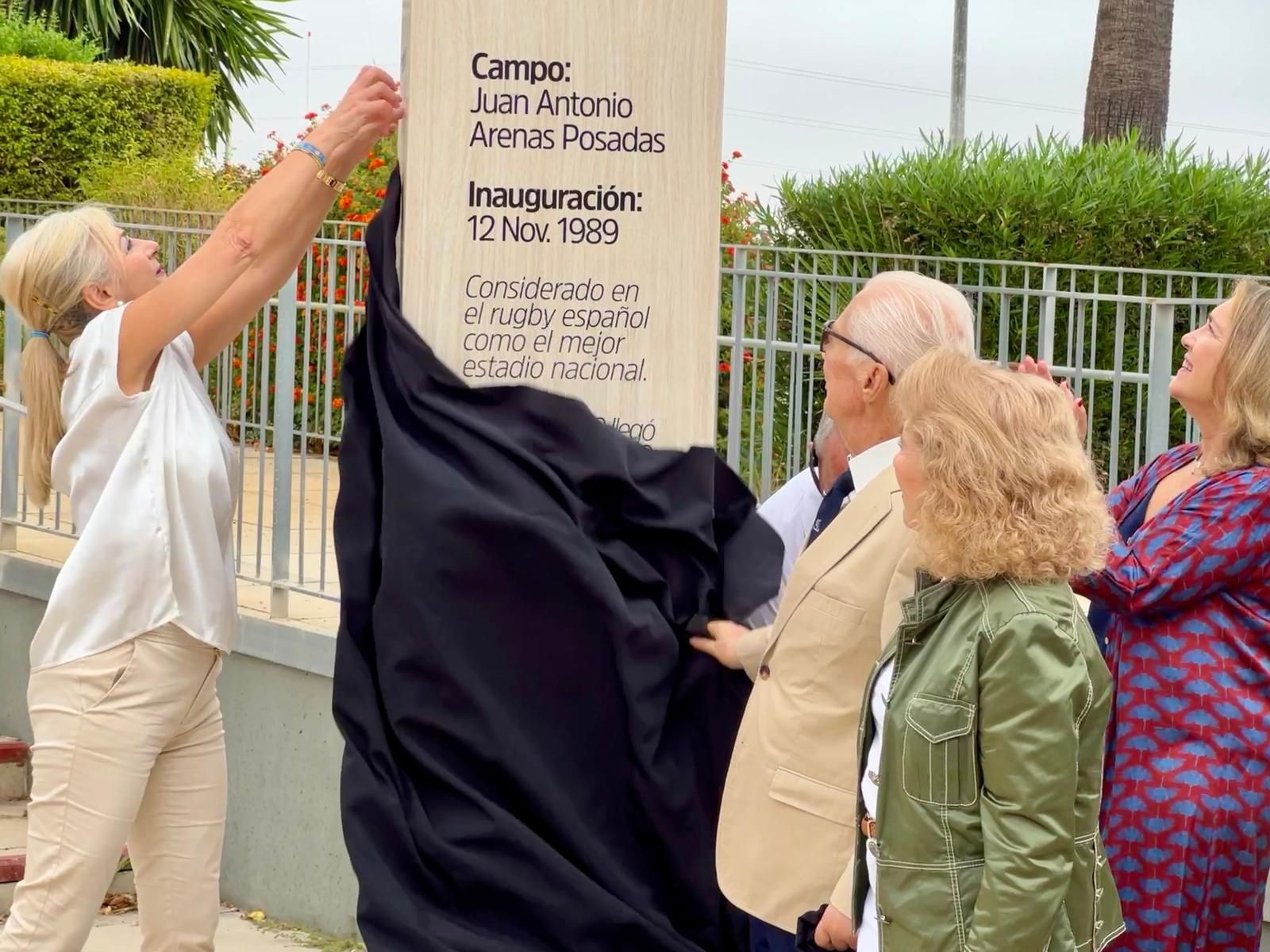 Arenas, a la derecha con chaqueta clara, descubre el cartel con su nombre en el campo de la Cartuja.