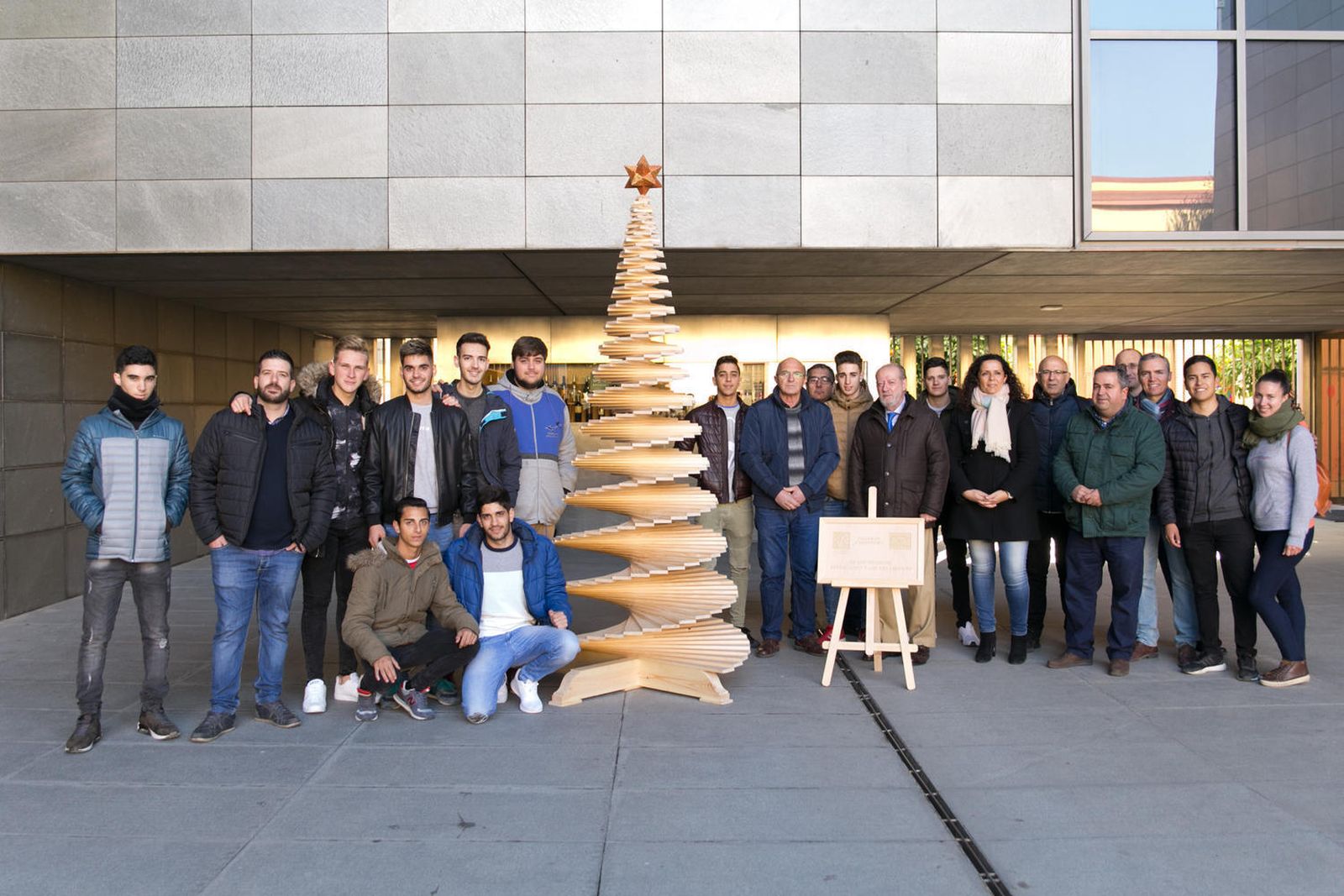 Los estudiantes posan con el presidente de la Diputación junto a su árbol.