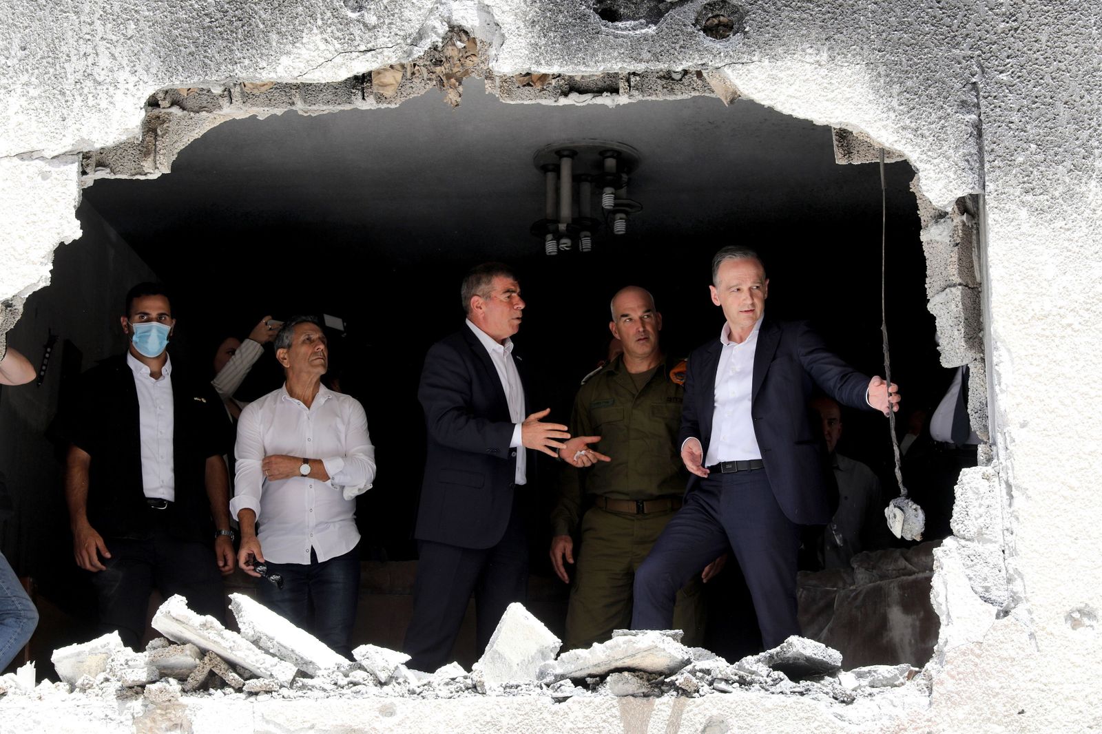 El ministro de Exteriores alemán, Heiko Maas (d), observa una casa bombardeada junto a su homólogo israelí, Gabi Ashkenazi, en la ciudad de Petah Tikva.