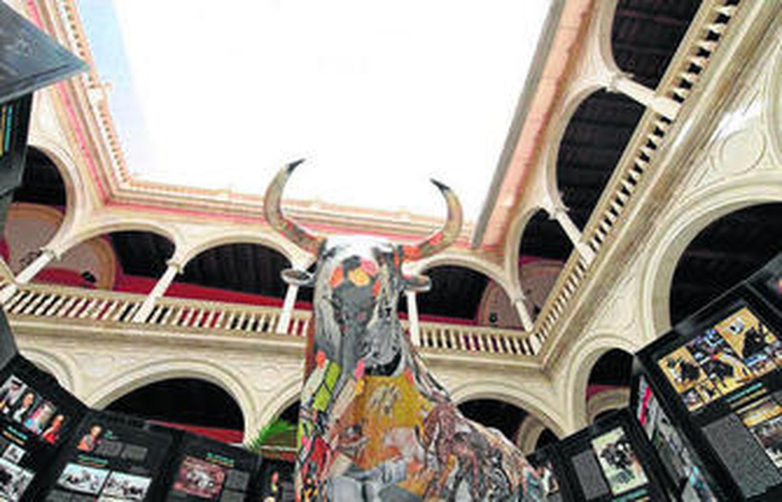 Un toro de poliestireno cubierto por un collage de figuras míticas del toreo en el centro del laberinto de paneles.