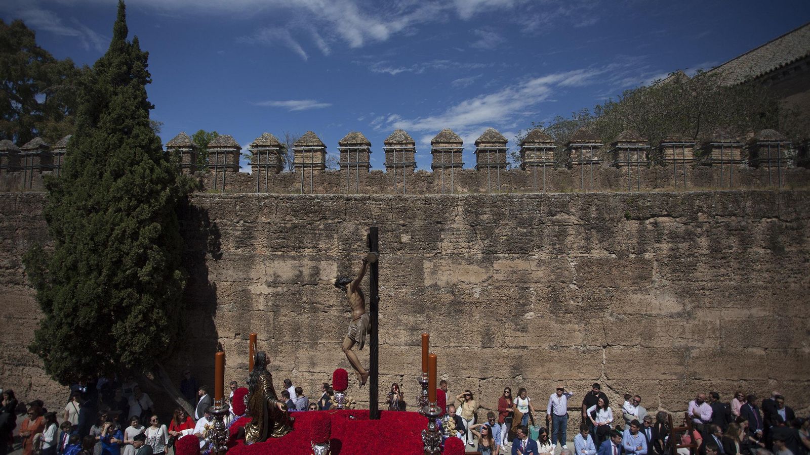 La silueta del Cristo de la Buena Muerte, de la cofradía de la Hiniesta, se recorta sobre la muralla.