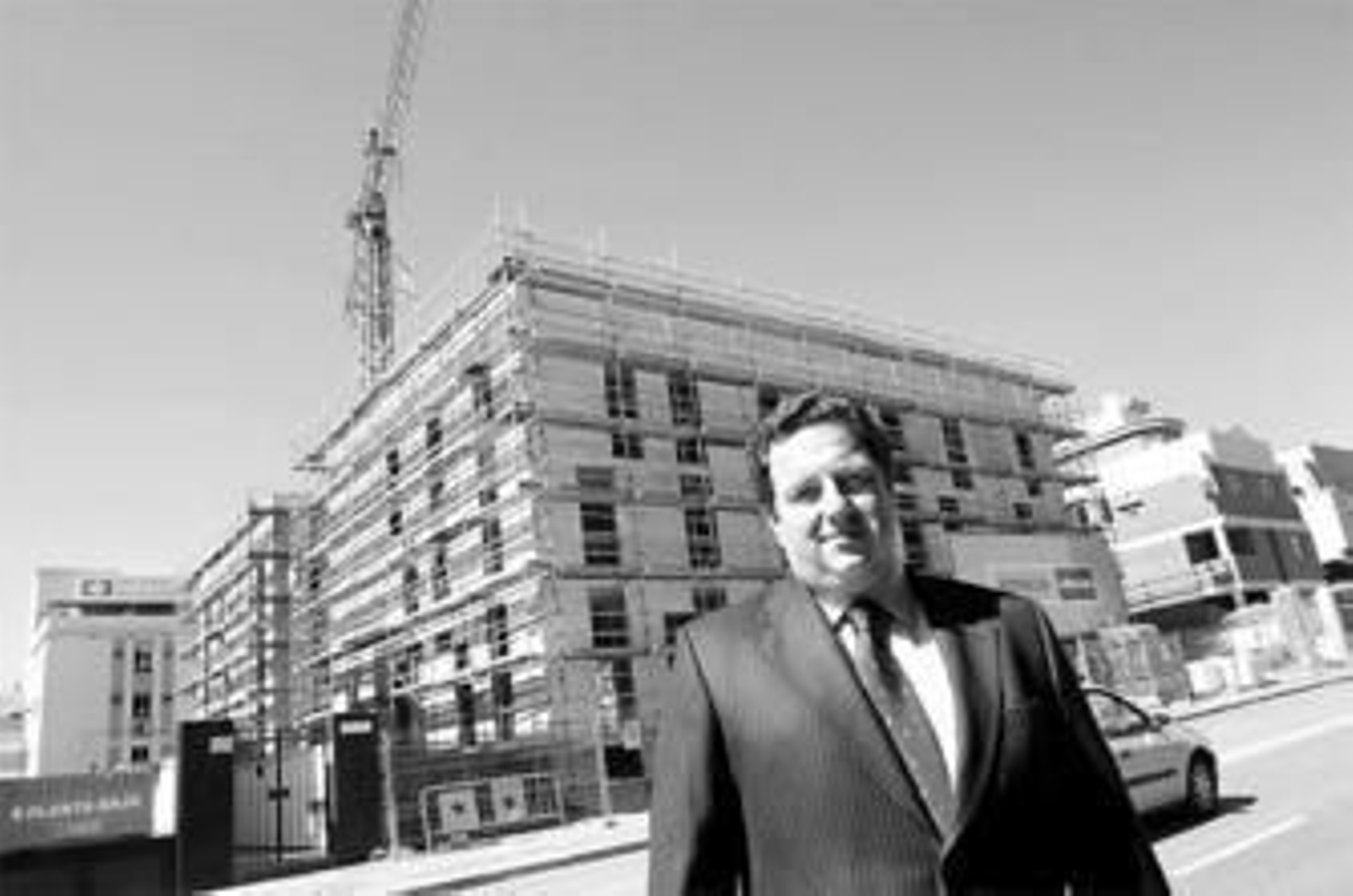 El gerente de La Encarnación, Jesús Burgos, con el nuevo edificio detrás. Al fondo, la actual clínica.