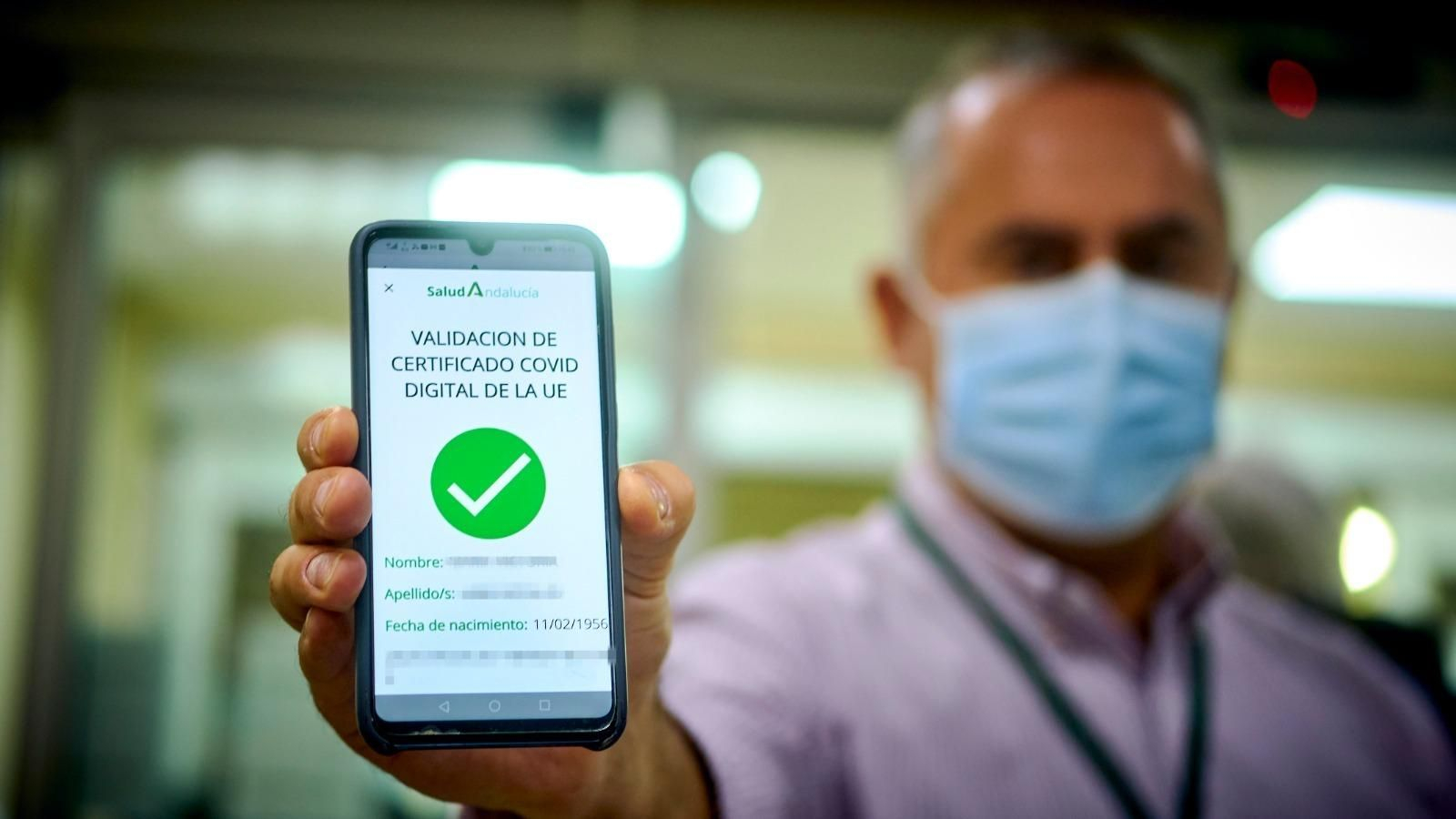 Un gaditano muestra su pasaporte covid en el hospital Puerta del Mar.