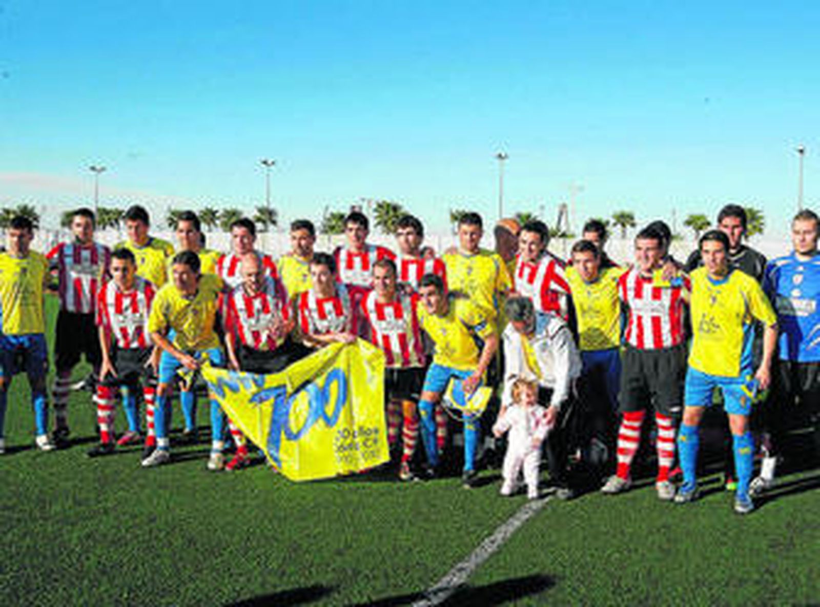 El Deportes Romero y el Cádiz posan con la bandera del Centenario antes del inicio del partido.