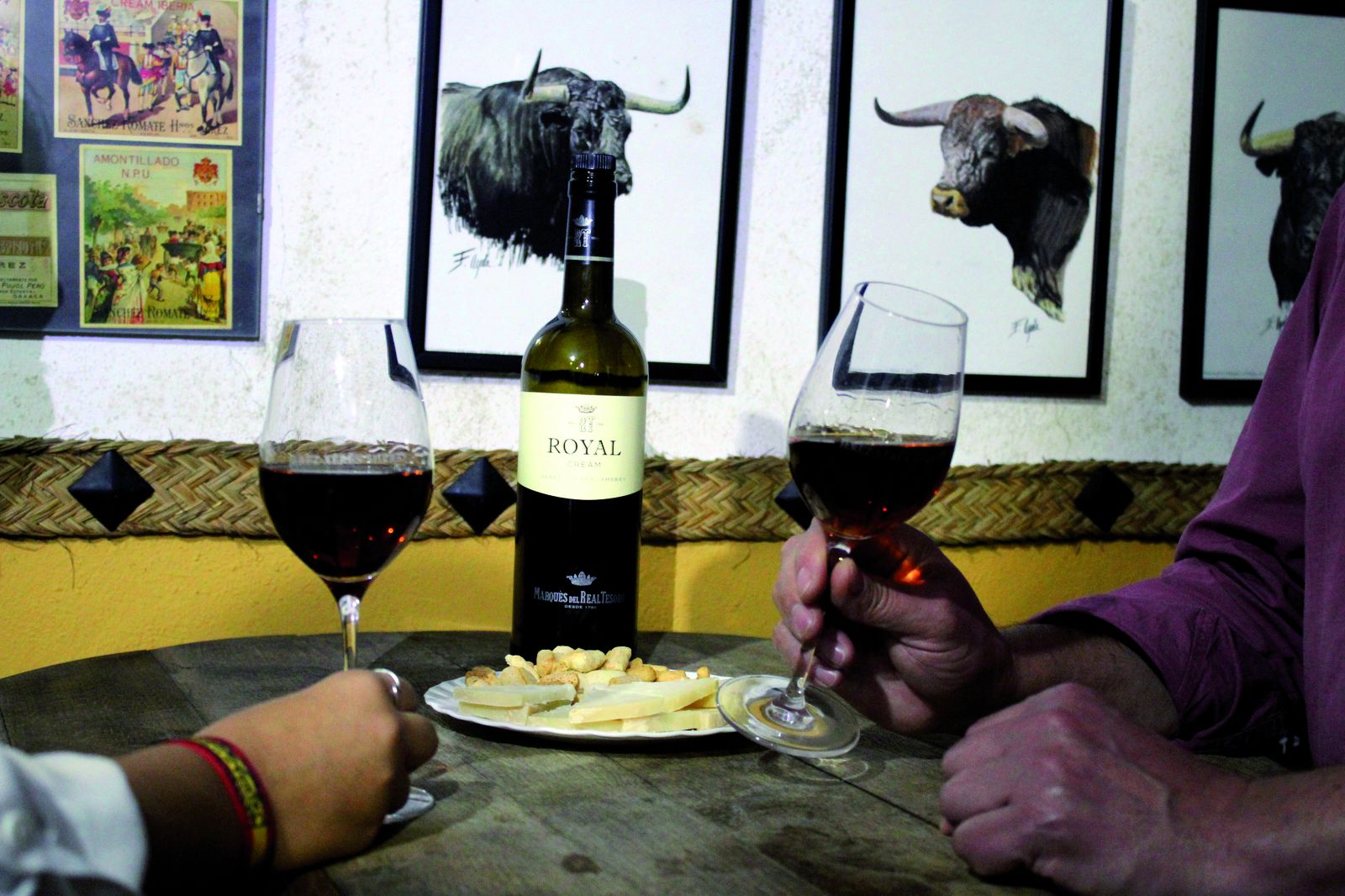 Una pareja disfrutando de unas copas de Royal Cream de Real Tesoro, con queso.