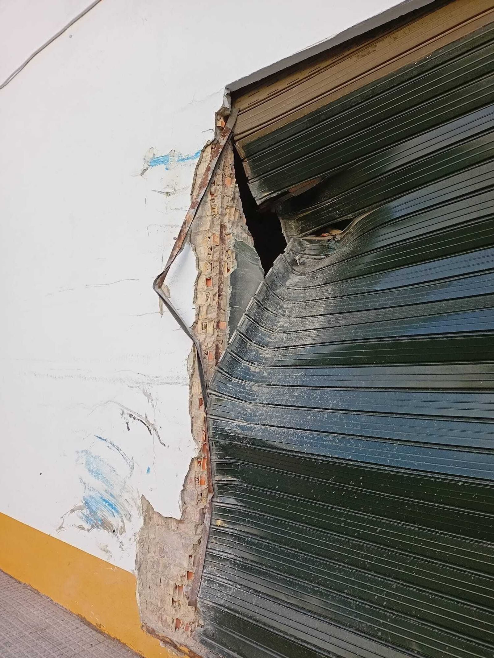 La puerta contra la que ha colisionado el autobús tras salir invadir la acera al salirse de la calzada en la rotonda.