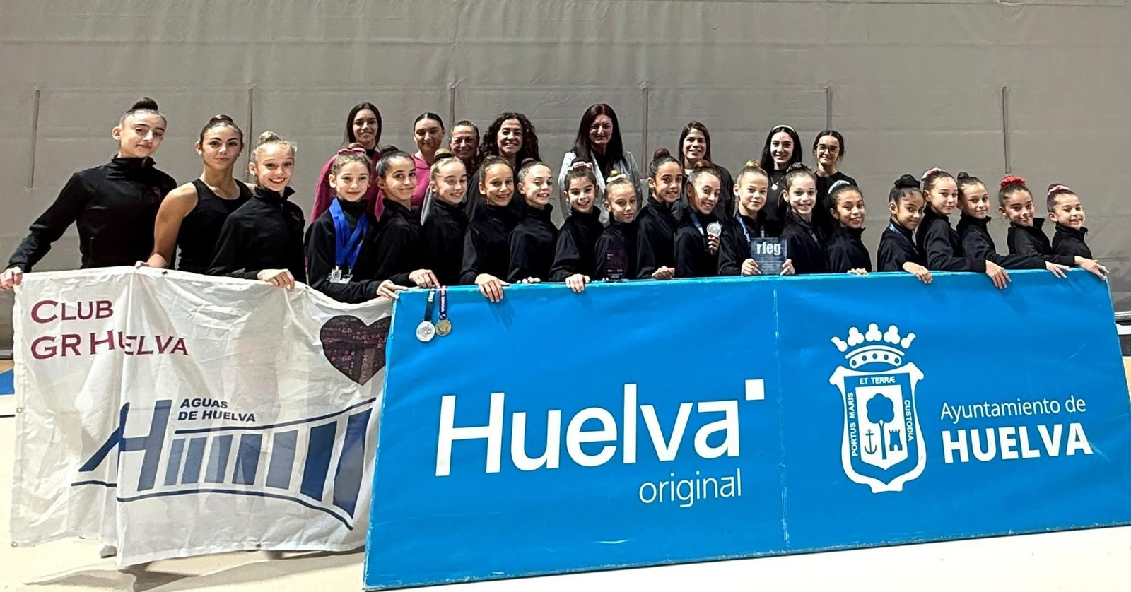 Gimnastas del GR Huelva posan con el patrocinio del Ayuntamiento y Aguas de Huelva.