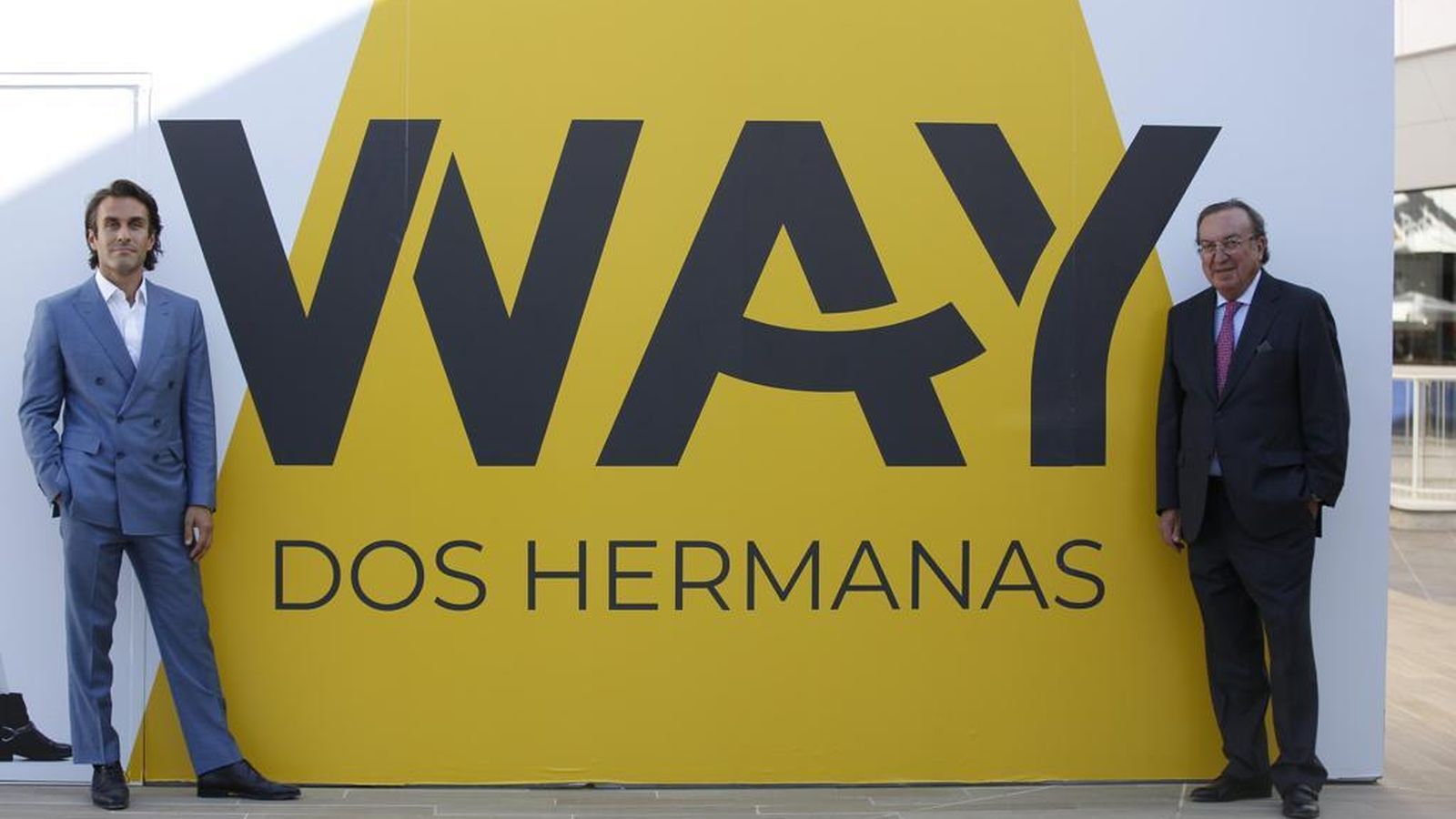 Saïd Hejal y Enrique Feduchy junto a uno de los carteles de WAY Dos Hermanas.