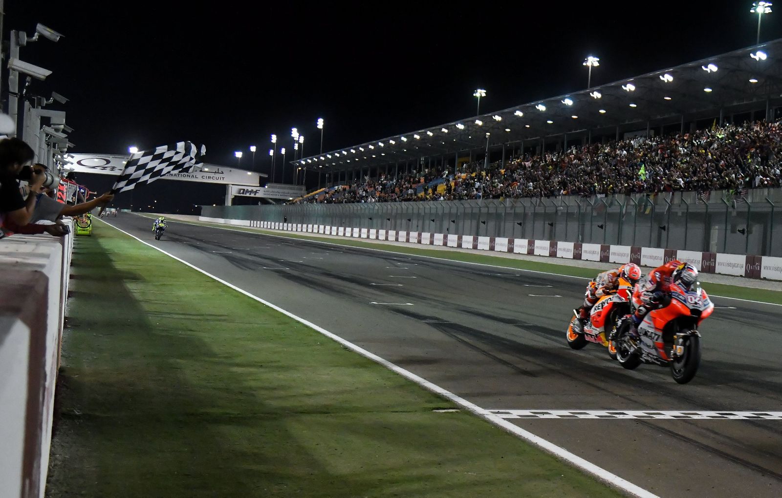 Andrea Dovizioso se impone casi sobre la línea de meta a Marc Márquez en el circuito de Losail.