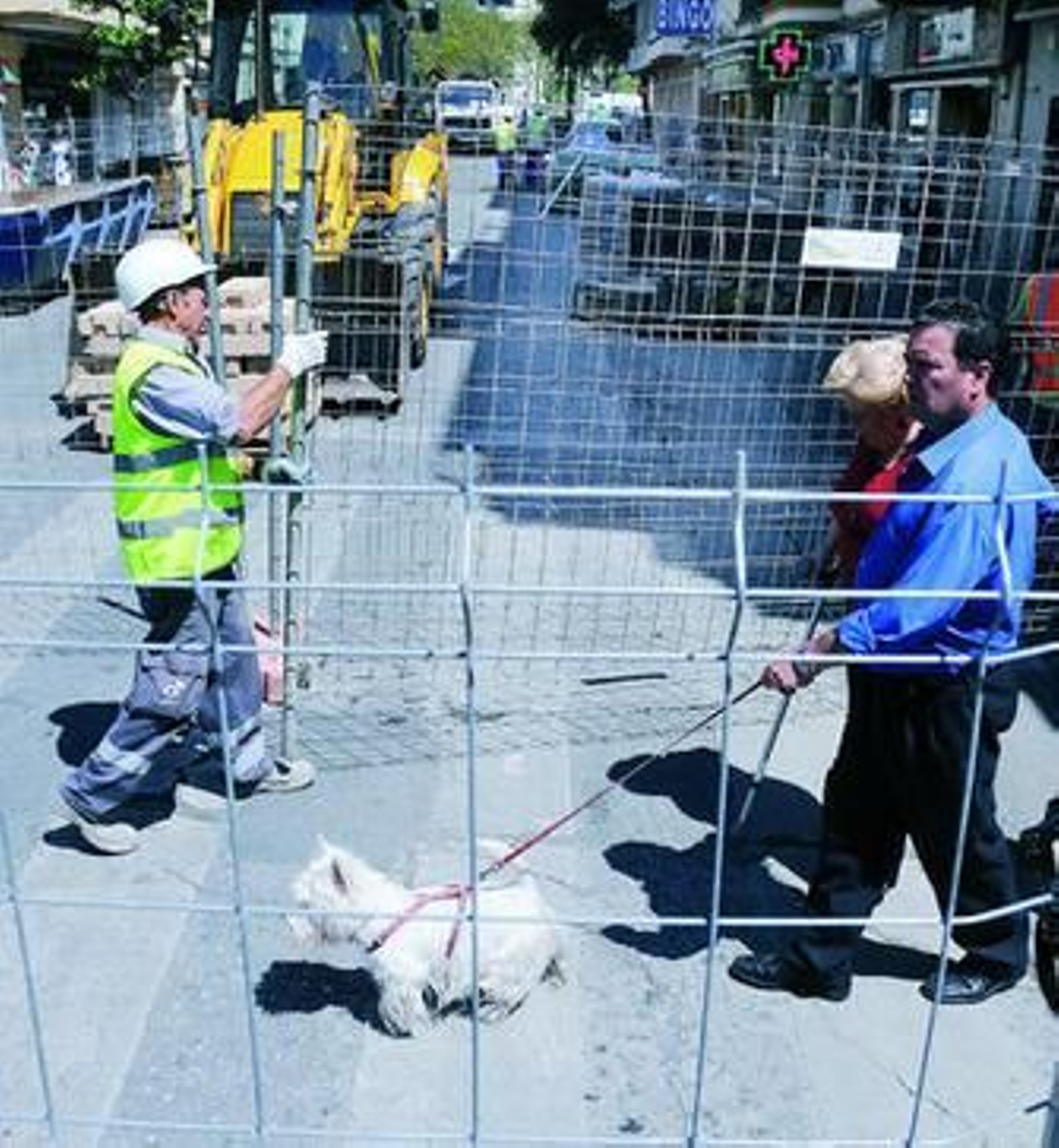 Dos peatones cruzan por los pasos abiertos entre las vallas que cierran la calle Asunción.